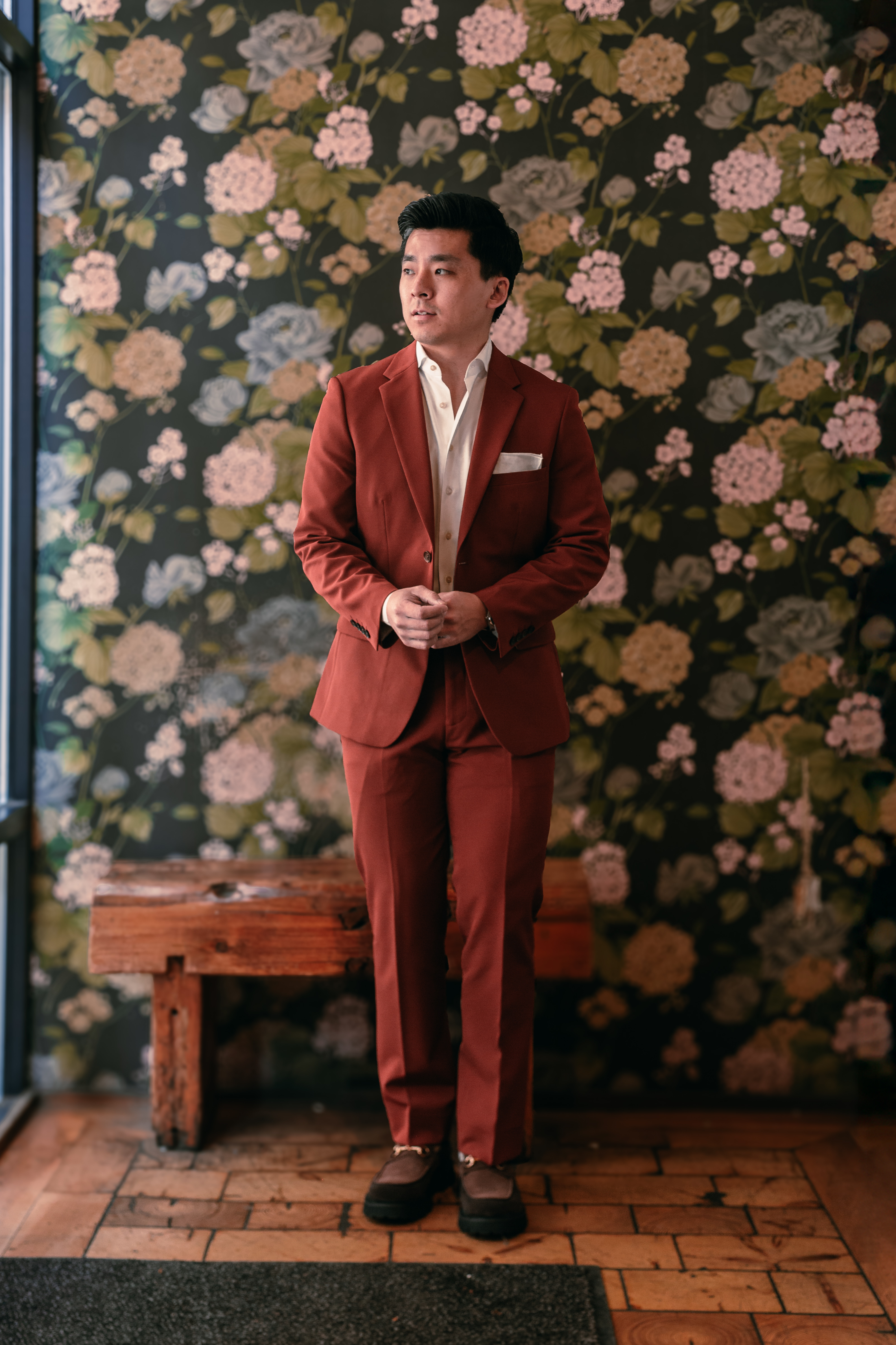 Groom wearing terracotta orange colorful suit