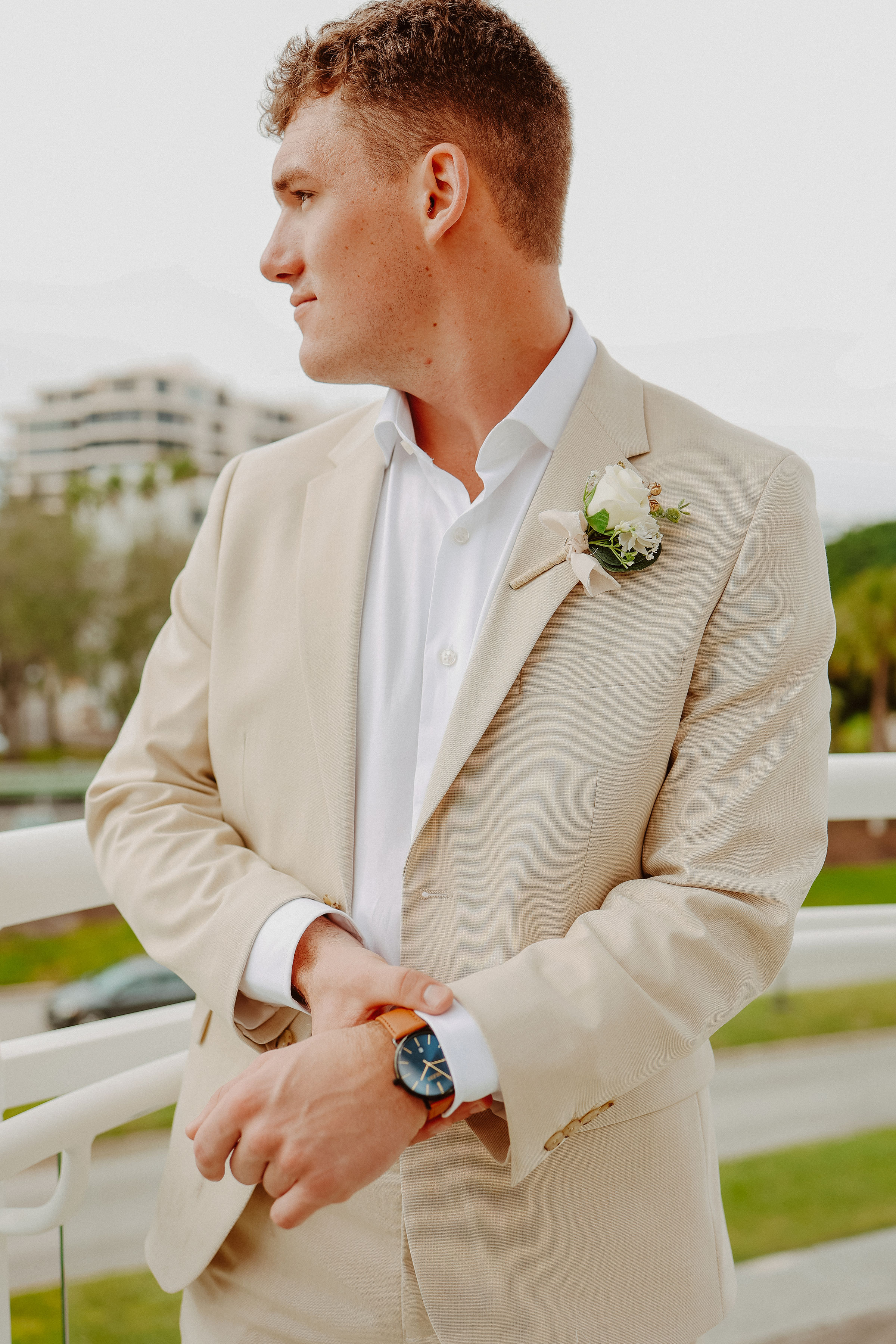 Groom wearing light tan suit for rehearsal dinner outfit
