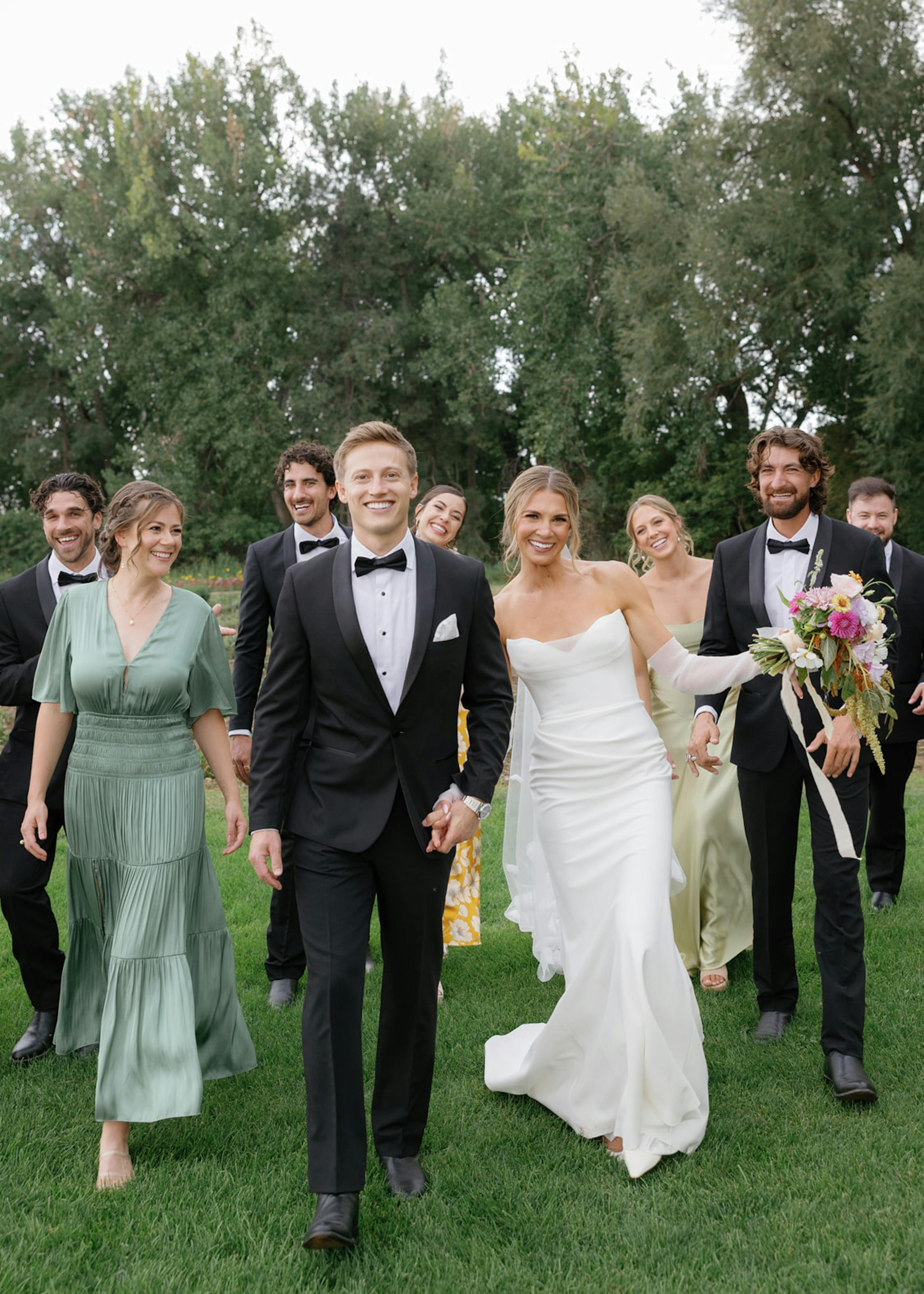 Sage green and butter yellow bridesmaid dresses with black groomsmen tuxedos