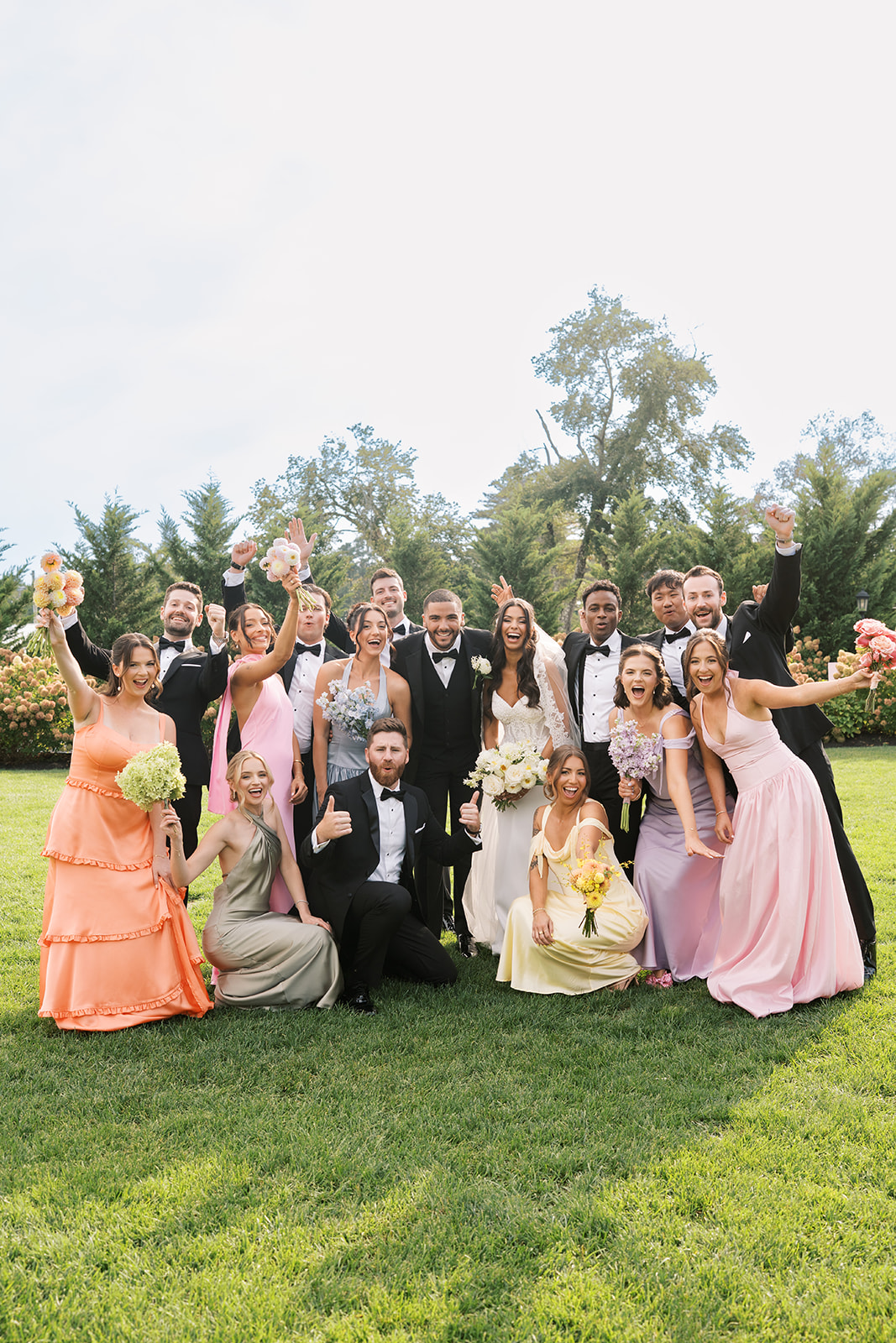 Mix and match bridesmaid dresses and groomsmen tuxedos at black tie floral wedding