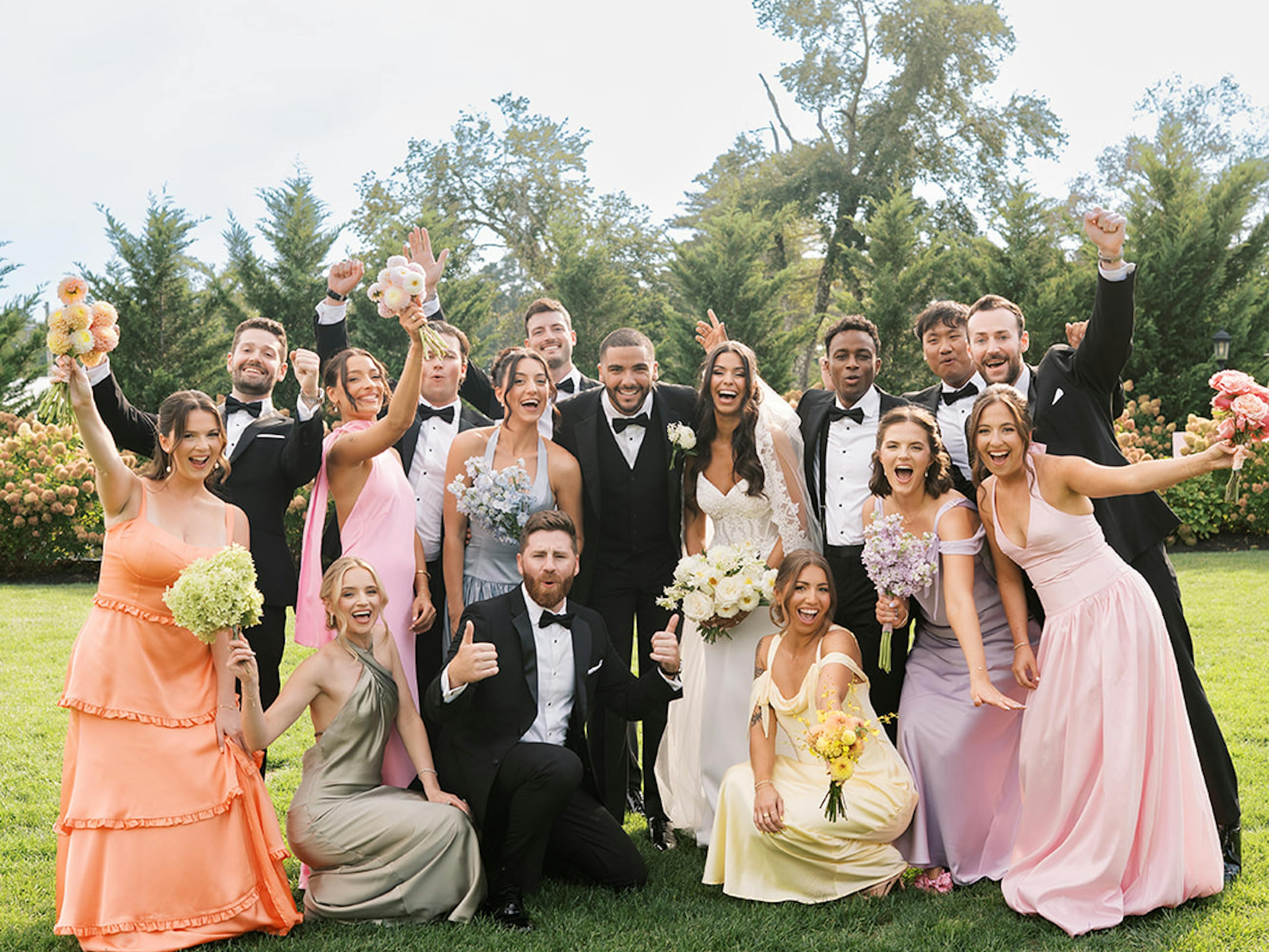 Mix and match bridesmaid dresses and groomsmen tuxedos at black tie floral wedding