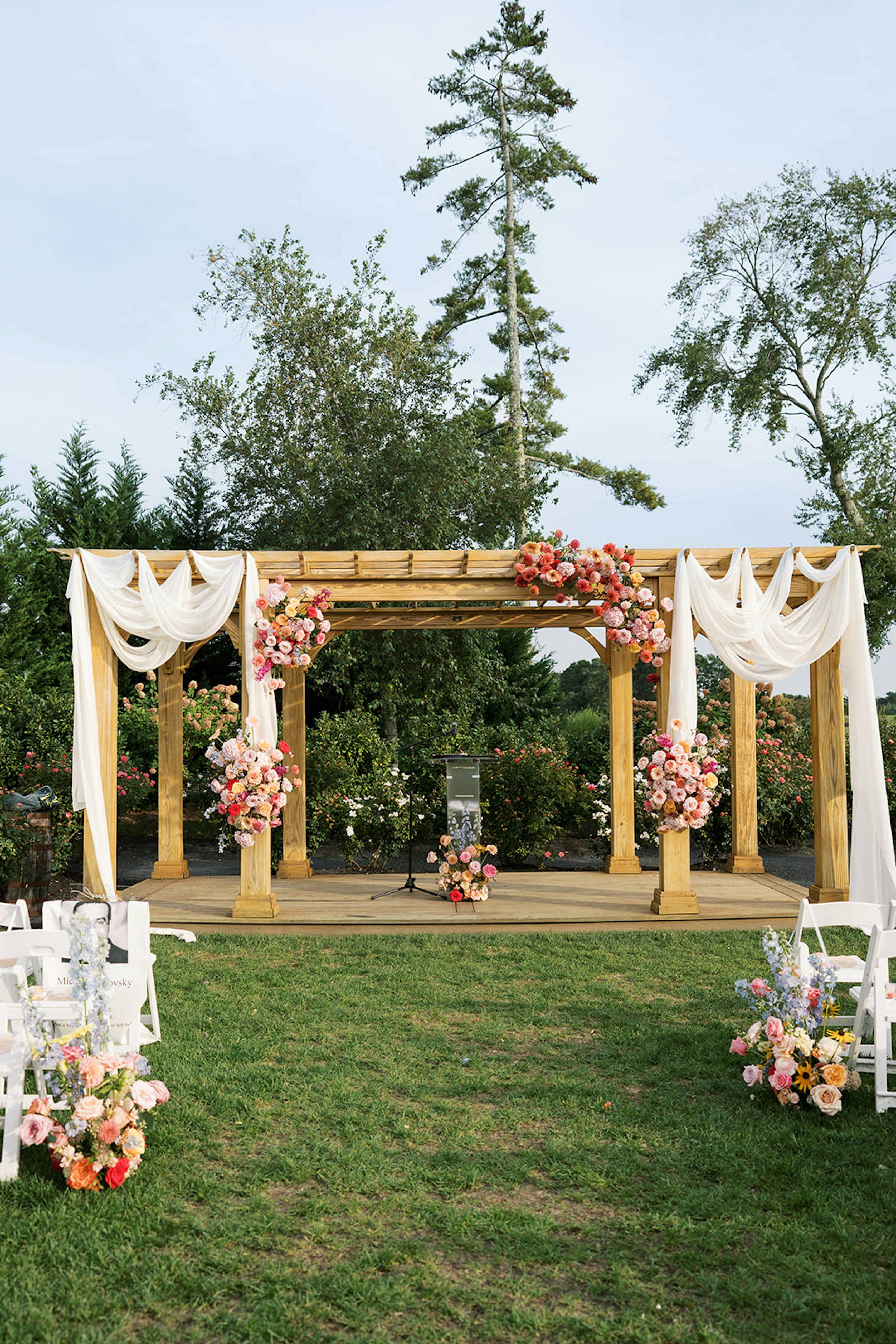 Altar set up with draped fabric for floral themed wedding at formal outdoor venue