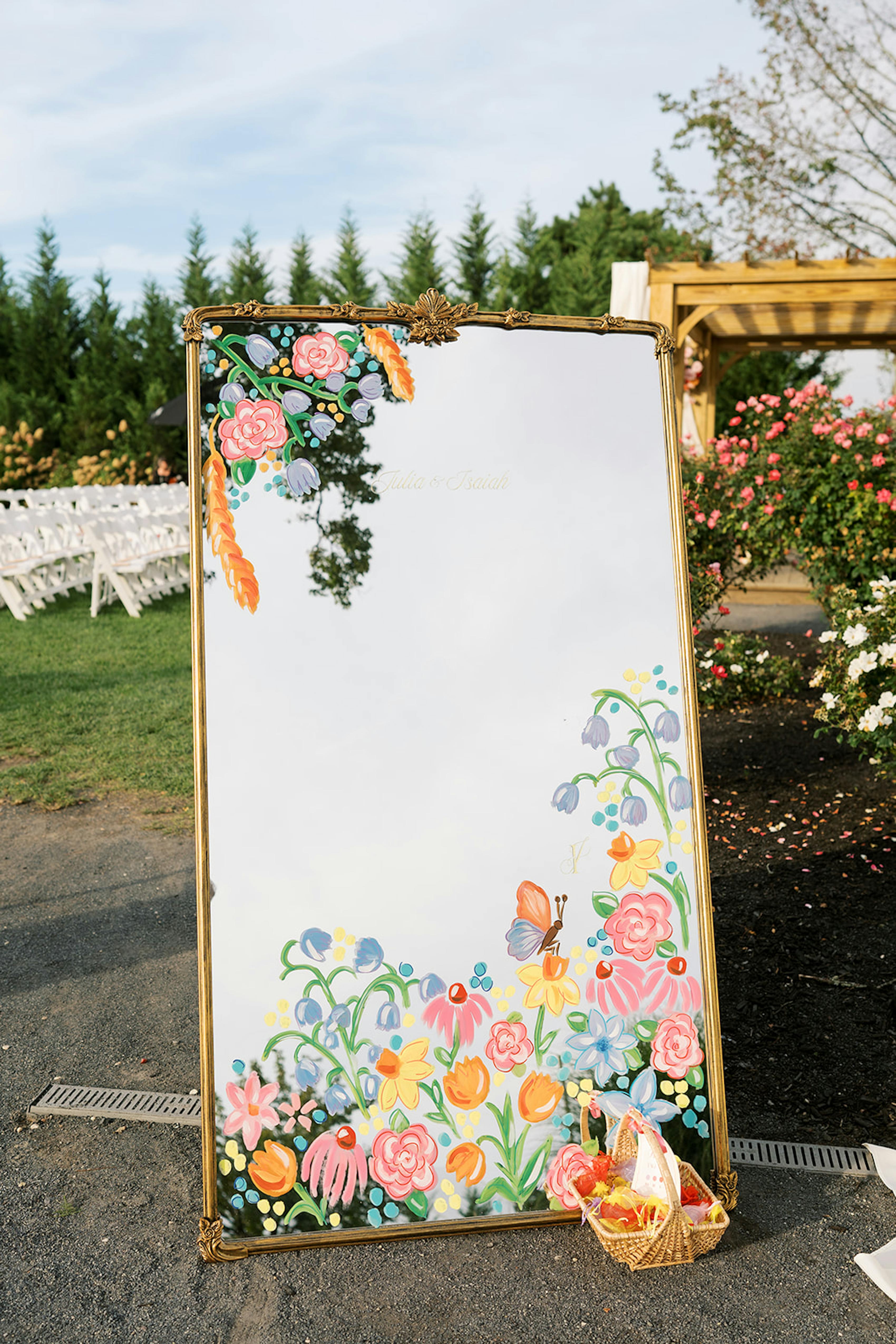 Hand painted florals on welcome mirror at wedding reception