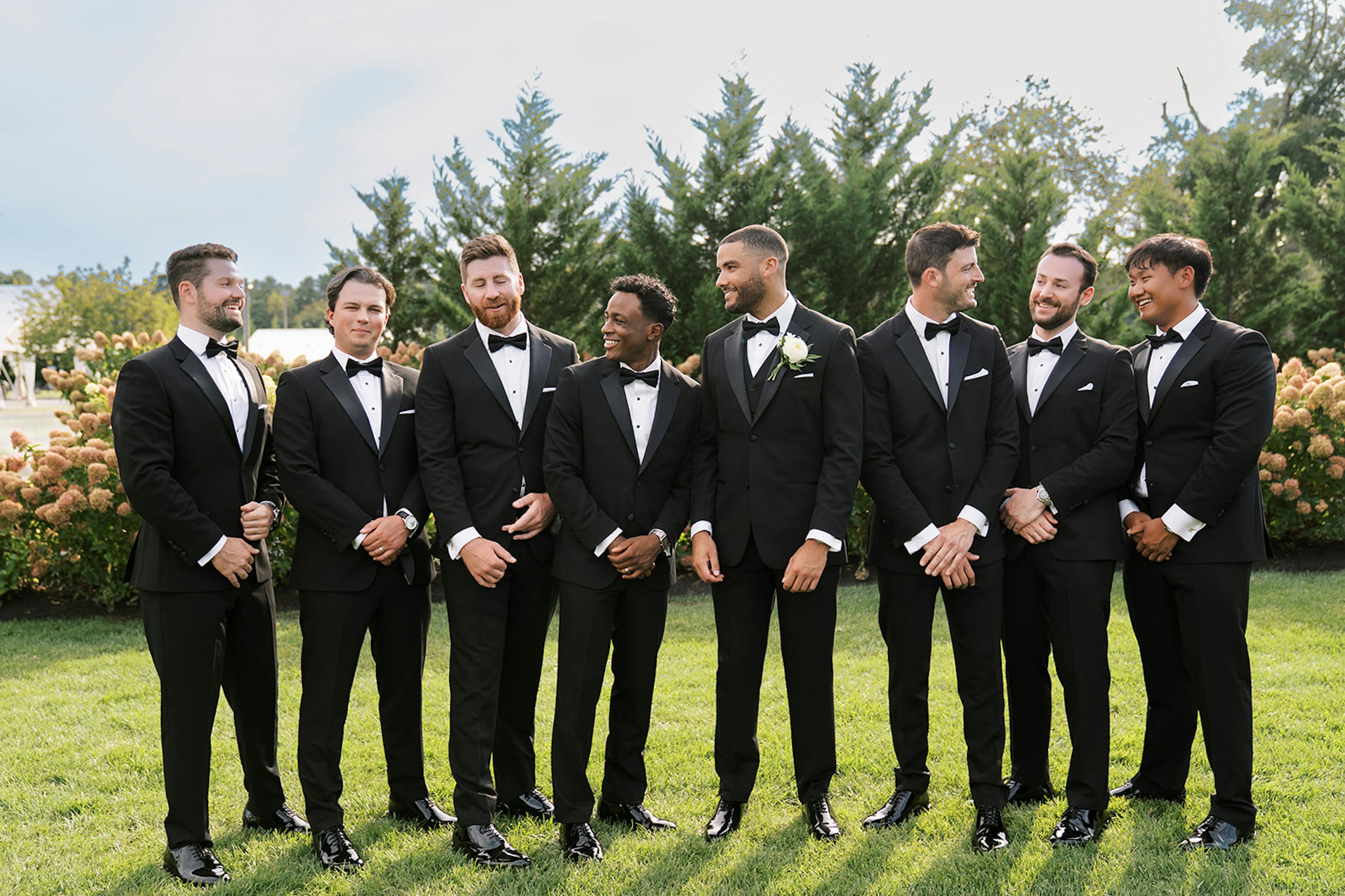 Black tie groomsmen wearing tuxedos at vineyard wedding