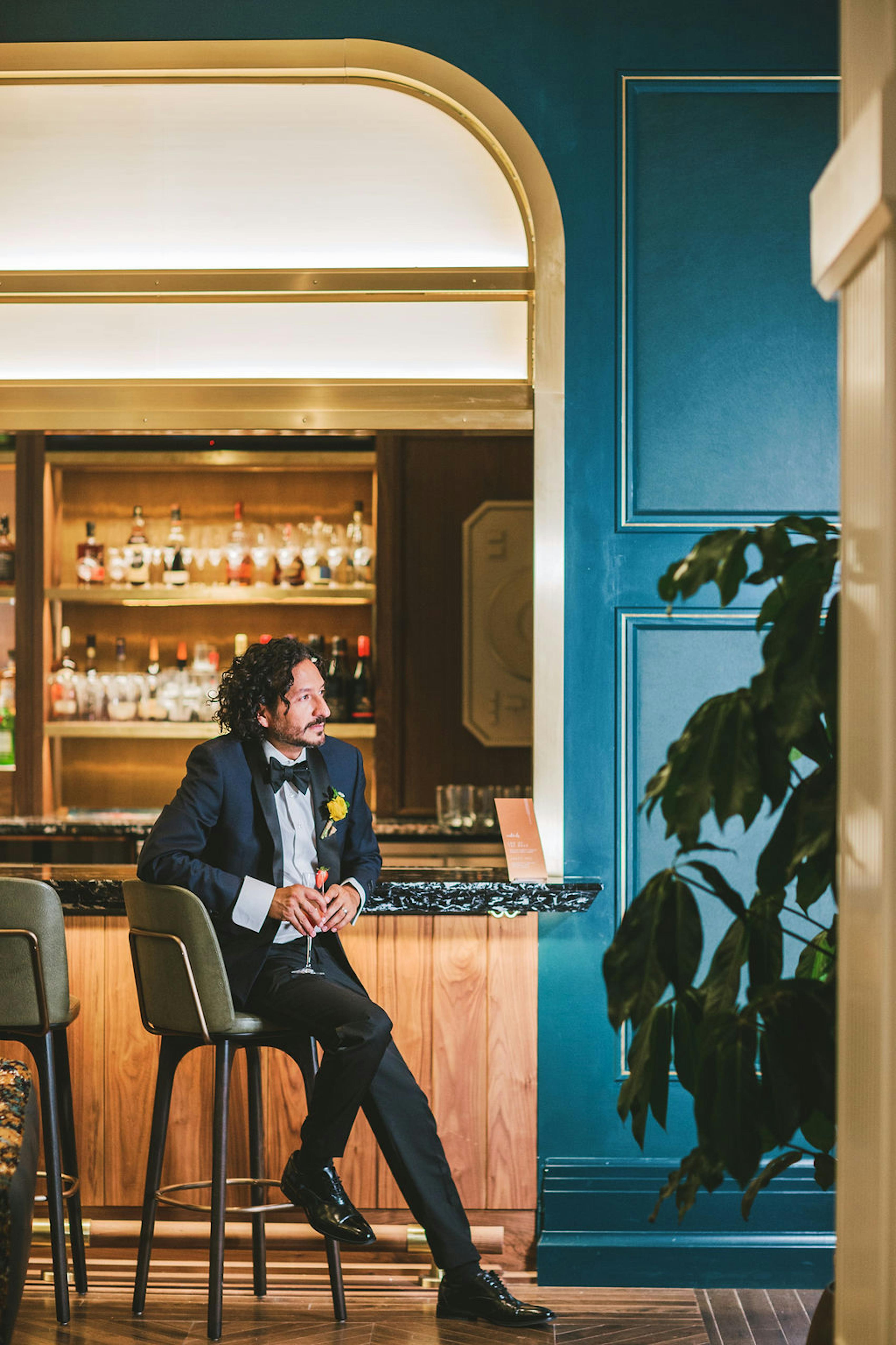 Groom at restaurant wedding venue wearing navy blue tuxedo