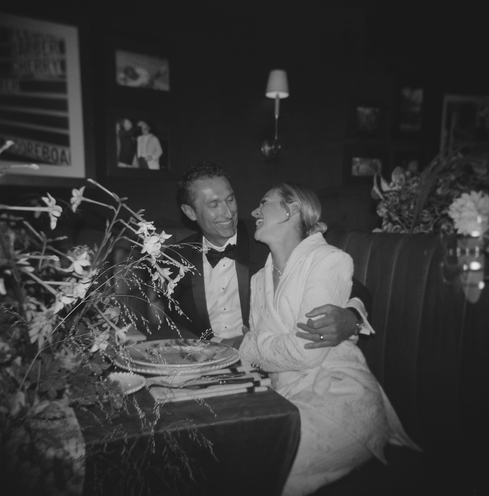 Bride and groom laughing together at intimate wedding restaurant booth