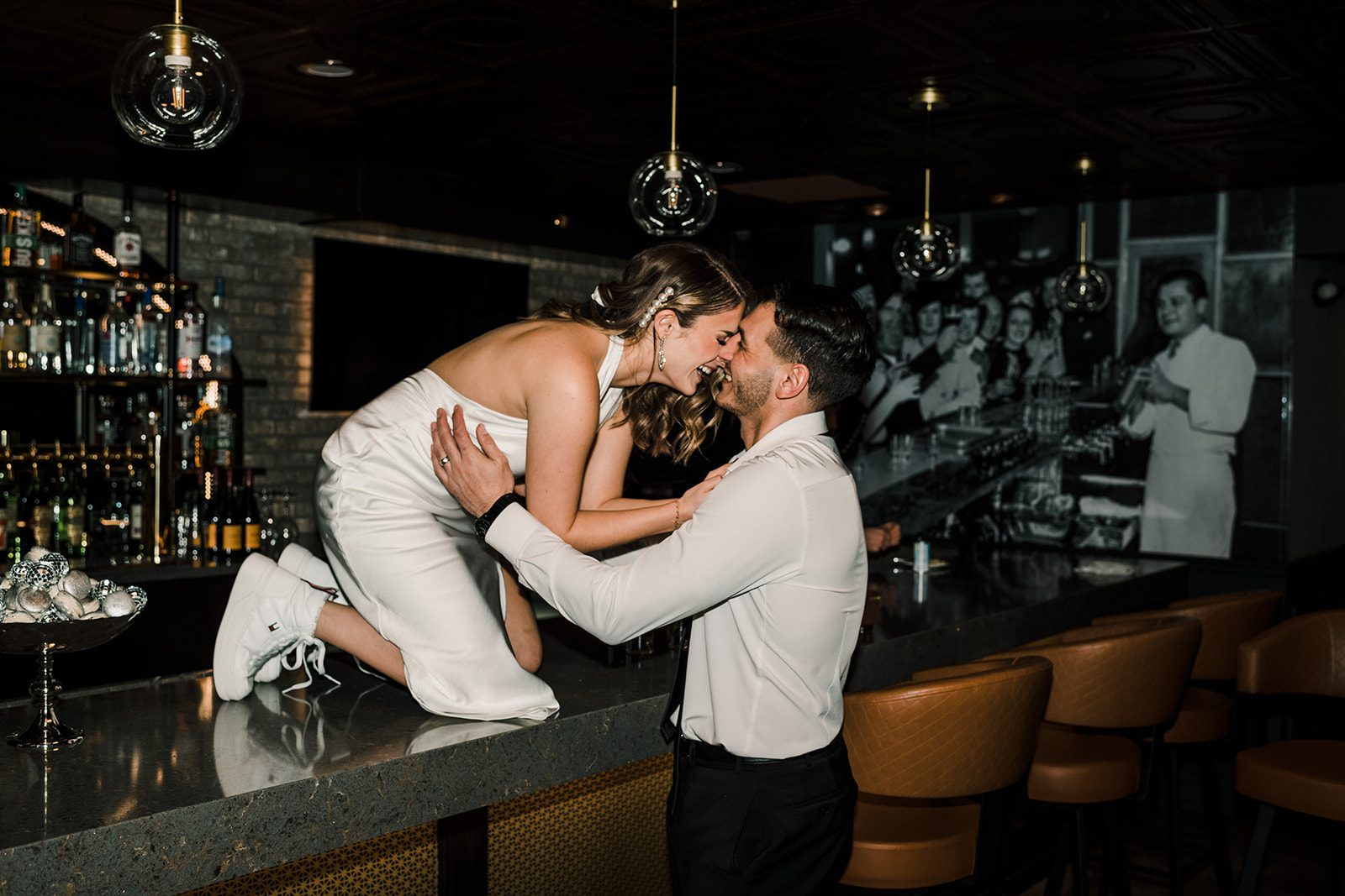 Bride and groom kissing on restaurant bar with flash photography