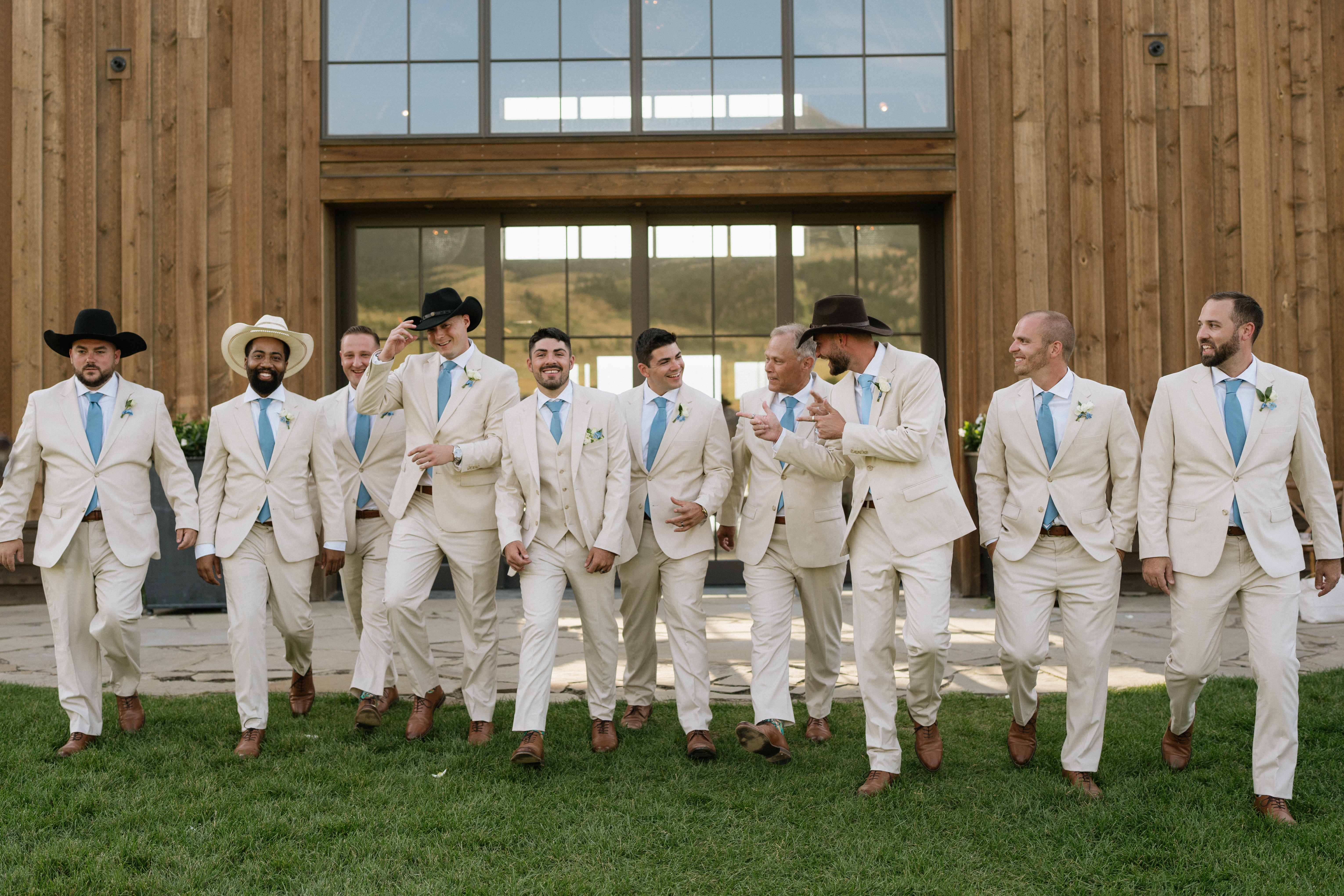 Western style groomsmen wearing tan wedding suits with light blue ties