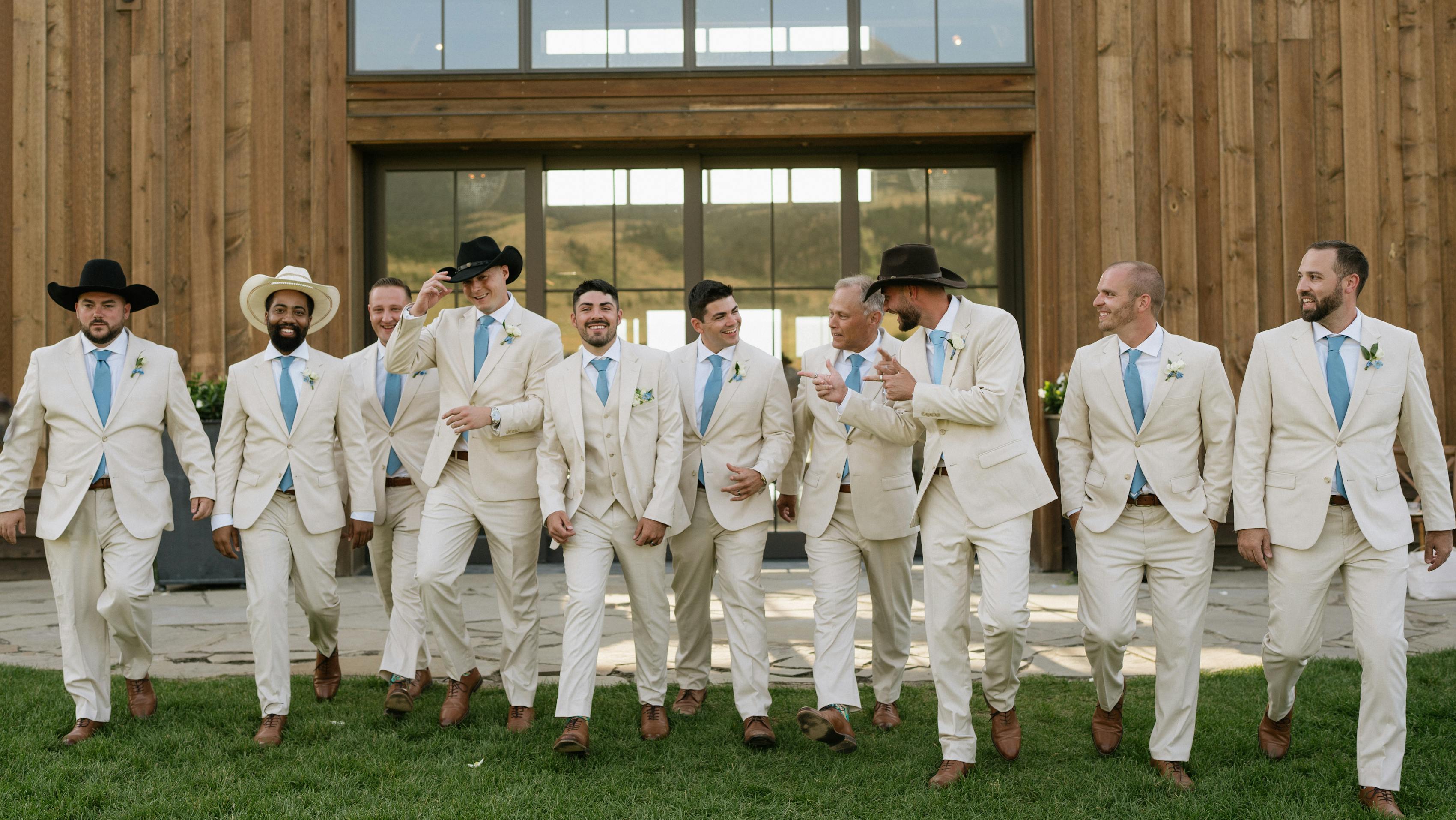 Western style groomsmen wearing tan wedding suits with light blue ties