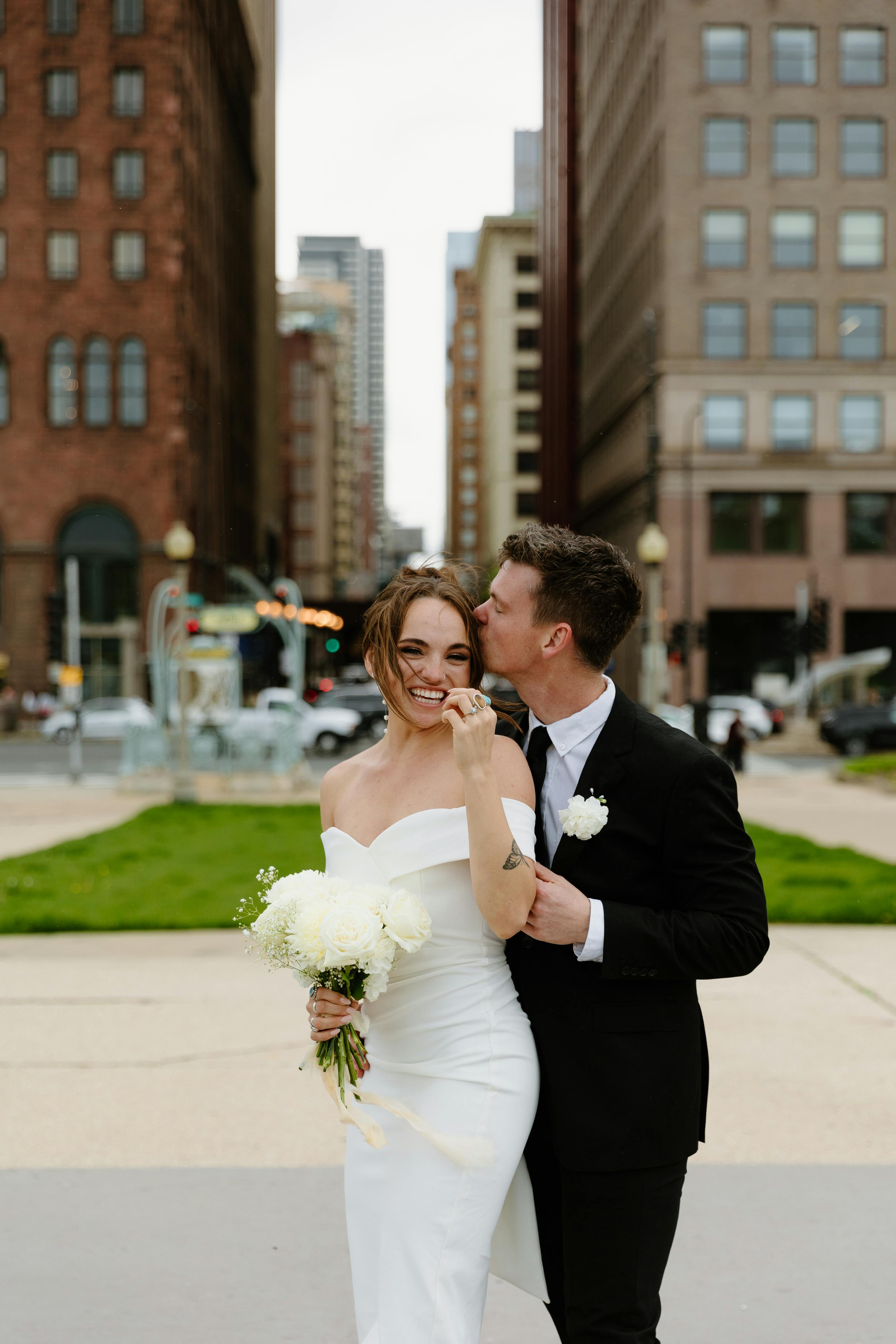 City wedding in the spring with black groom's suit and off the shoulder wedding dress