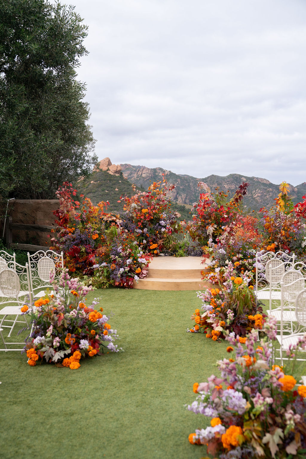 Mountain wedding venue with bold orange aisle and altar floral design