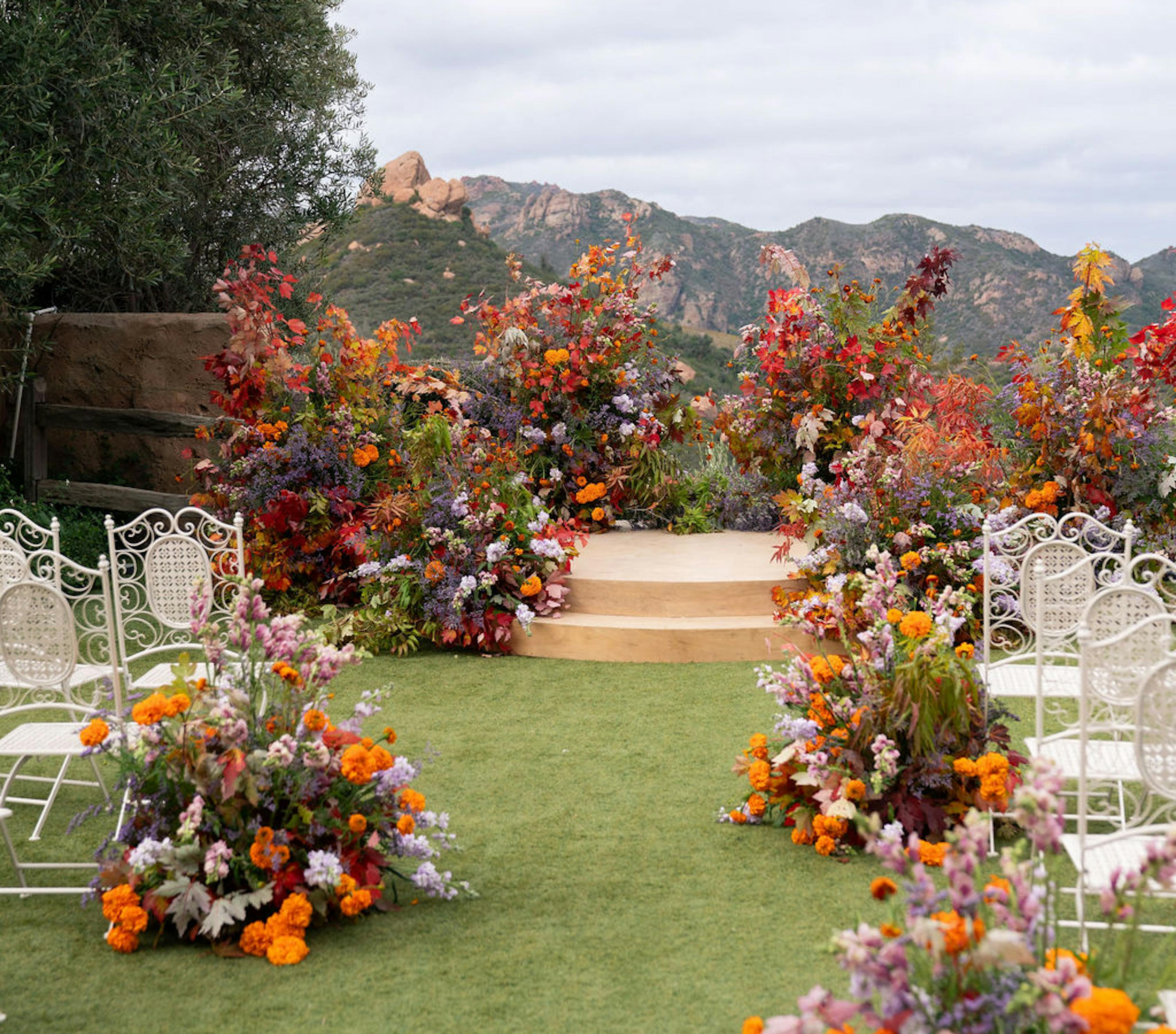 Mountain wedding venue with bold orange aisle and altar floral design