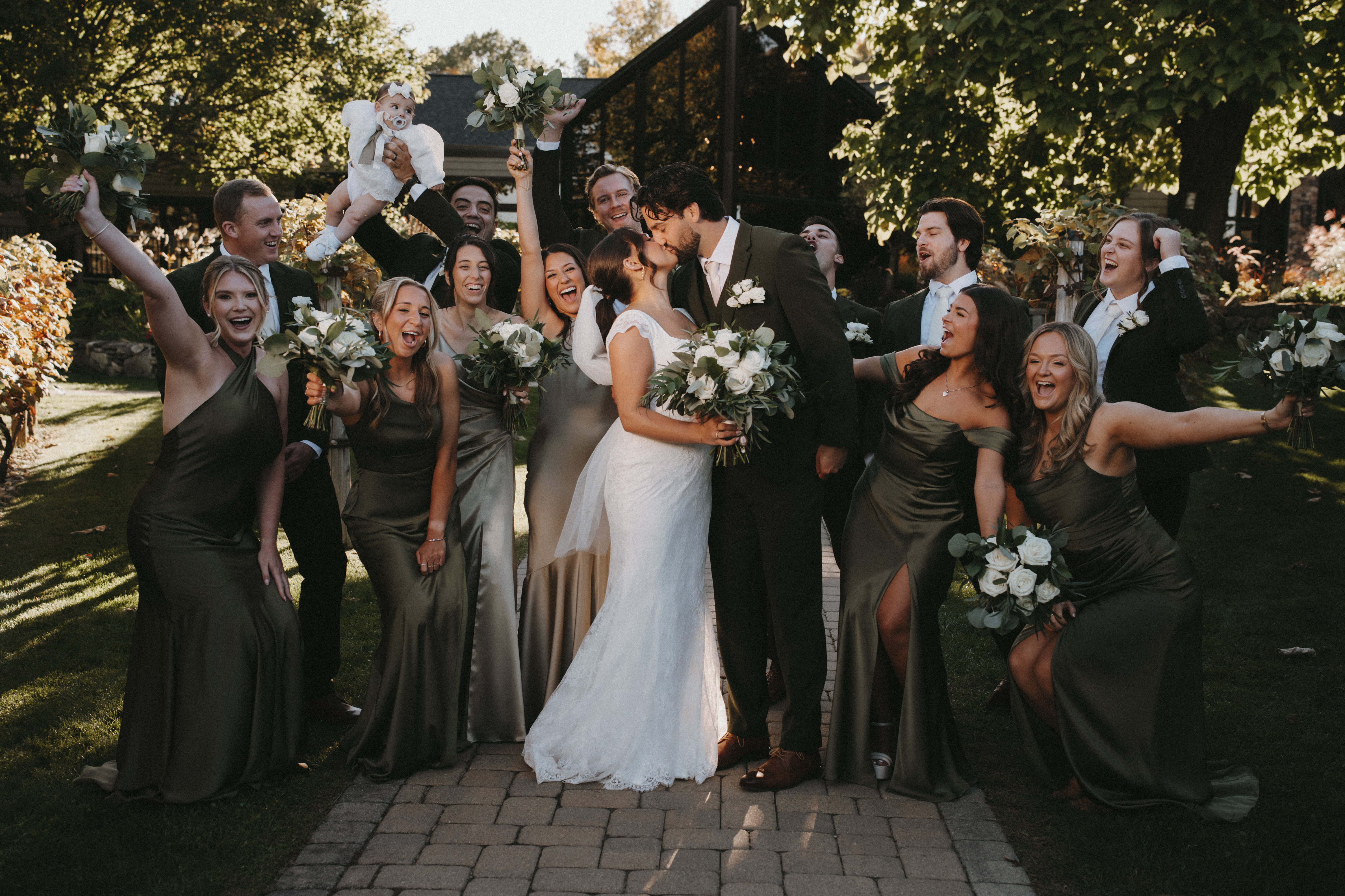 Olive green wedding theme with green groomsman suits and satin bridesmaid dresses