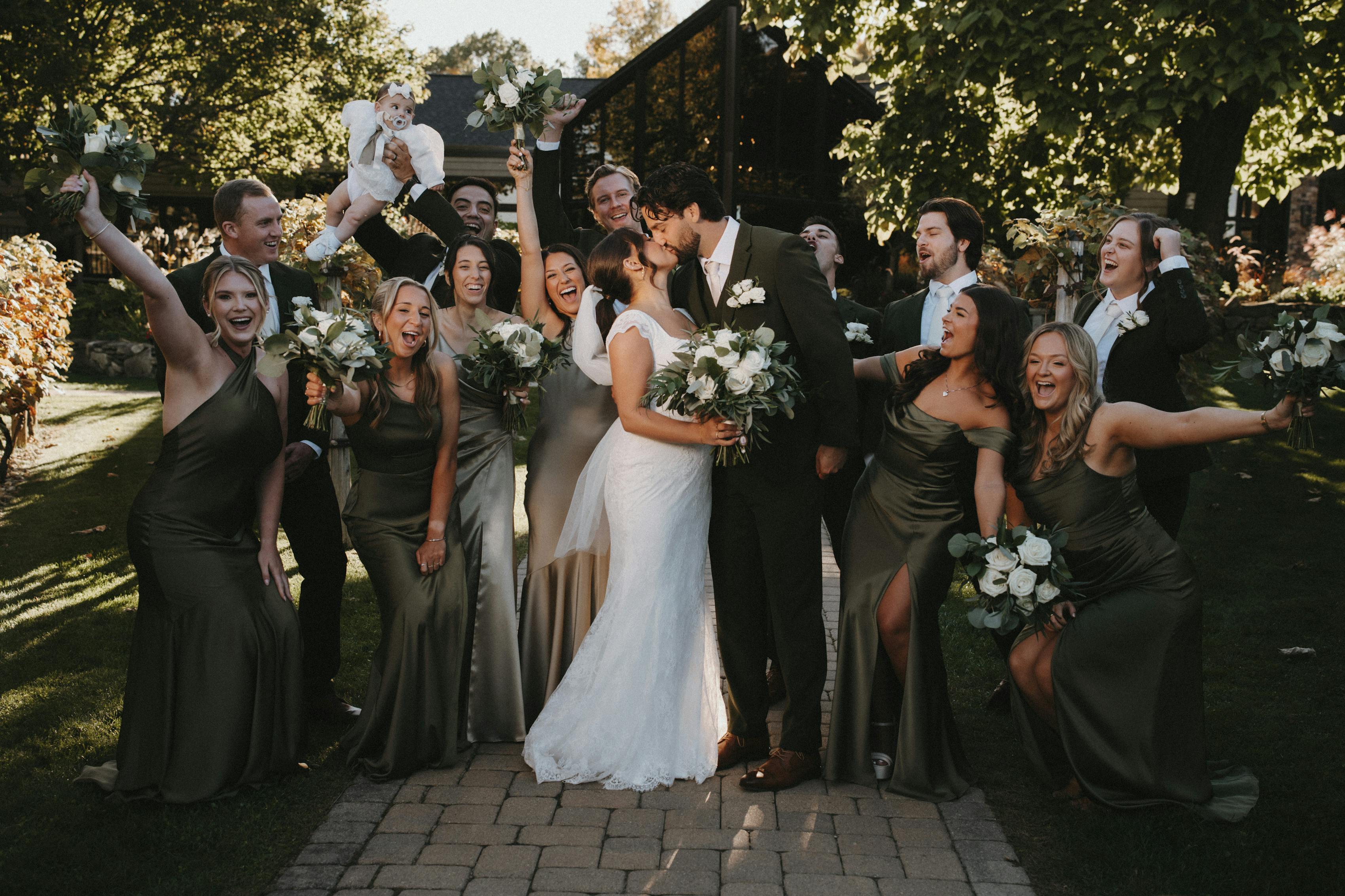 Olive green wedding theme with green groomsman suits and satin bridesmaid dresses