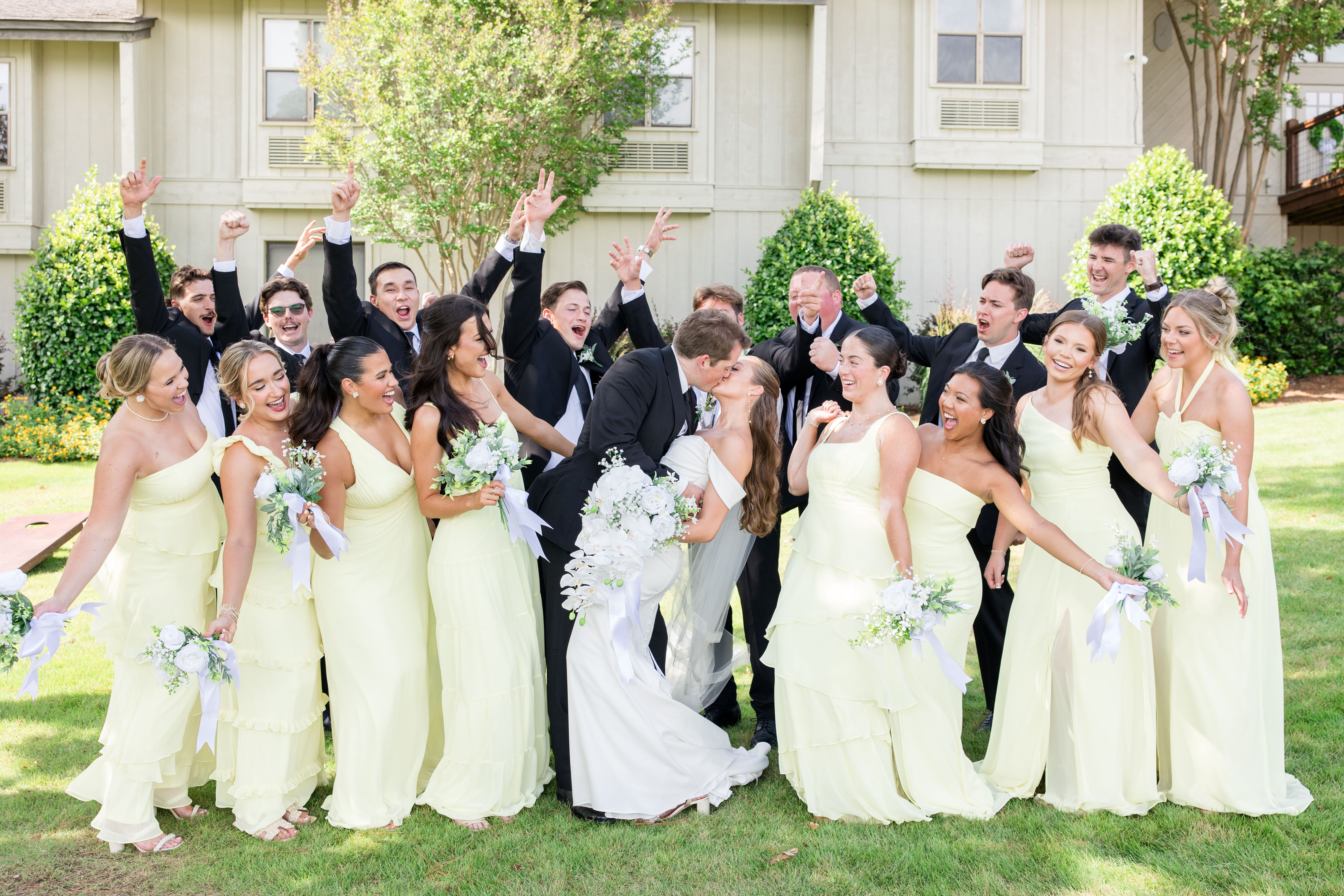 Bridesmaids in light lime green dresses with groomsmen in black tuxedos
