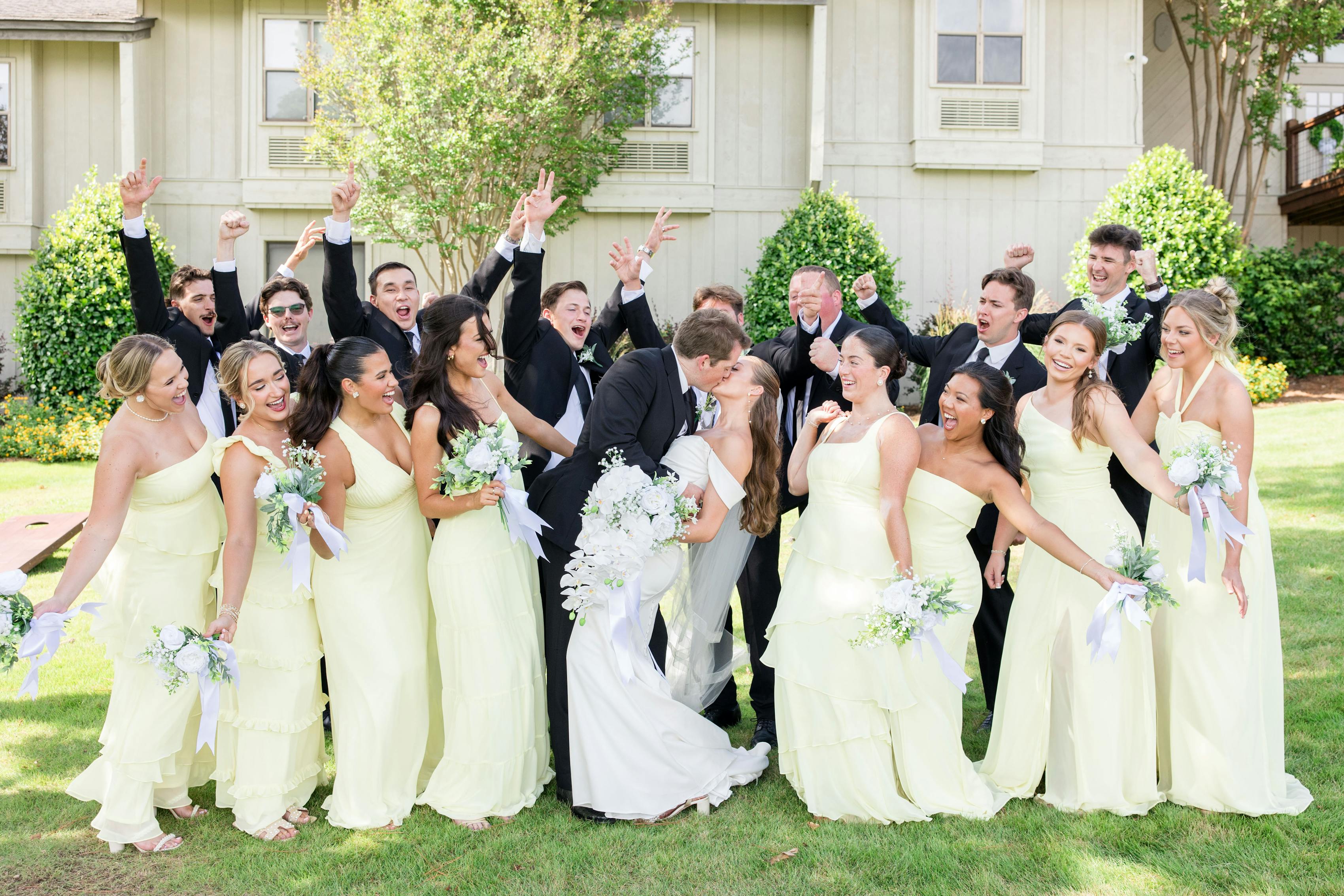 Bridesmaids in light lime green dresses with groomsmen in black tuxedos