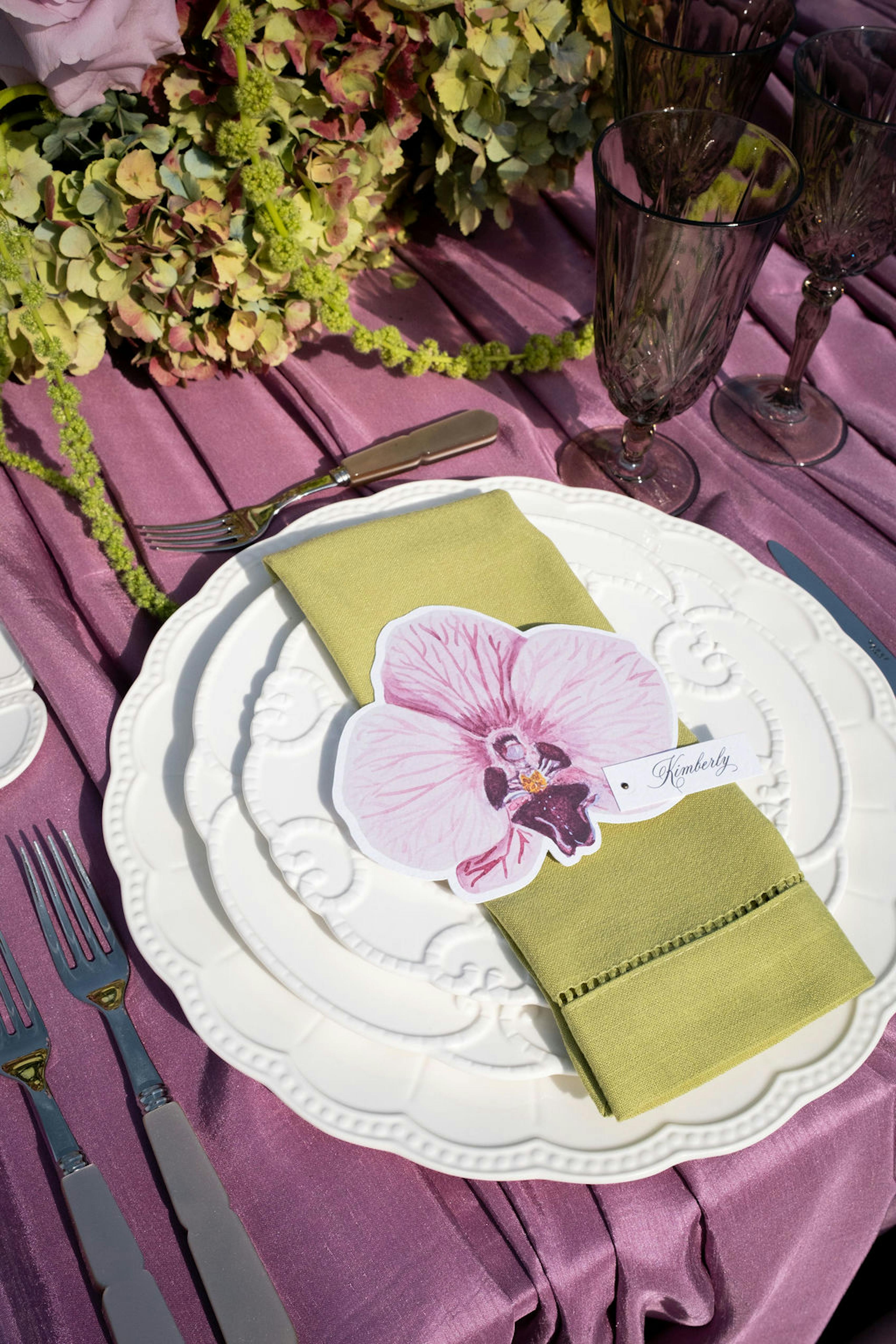 Island citrus wedding tablescape with purple mauve tablecloth and lime napkins and yellow florals