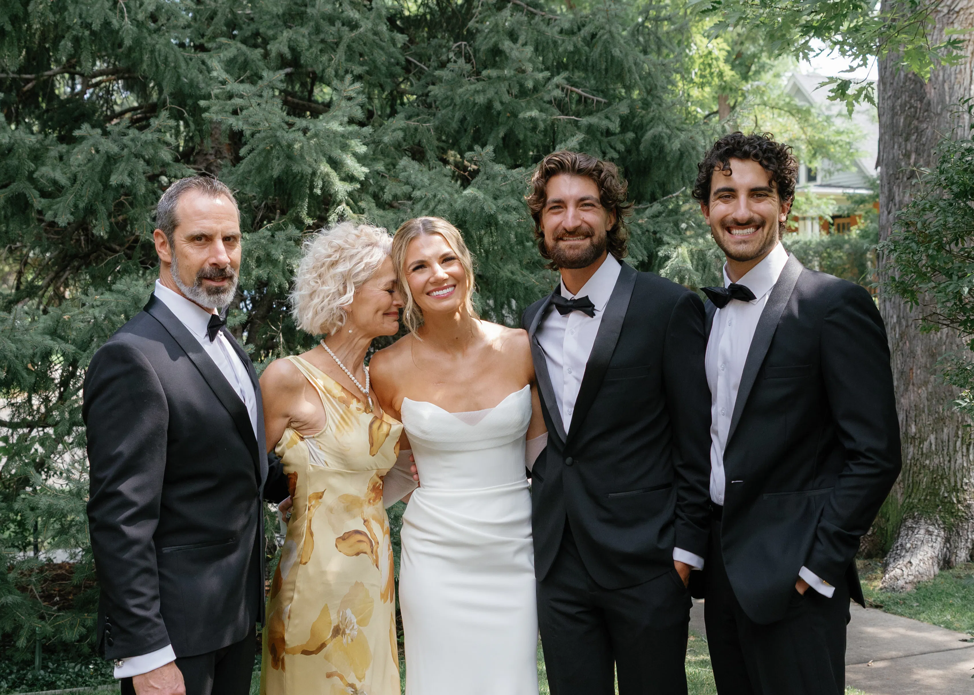 The bride's family poses together for a photo in the woods.