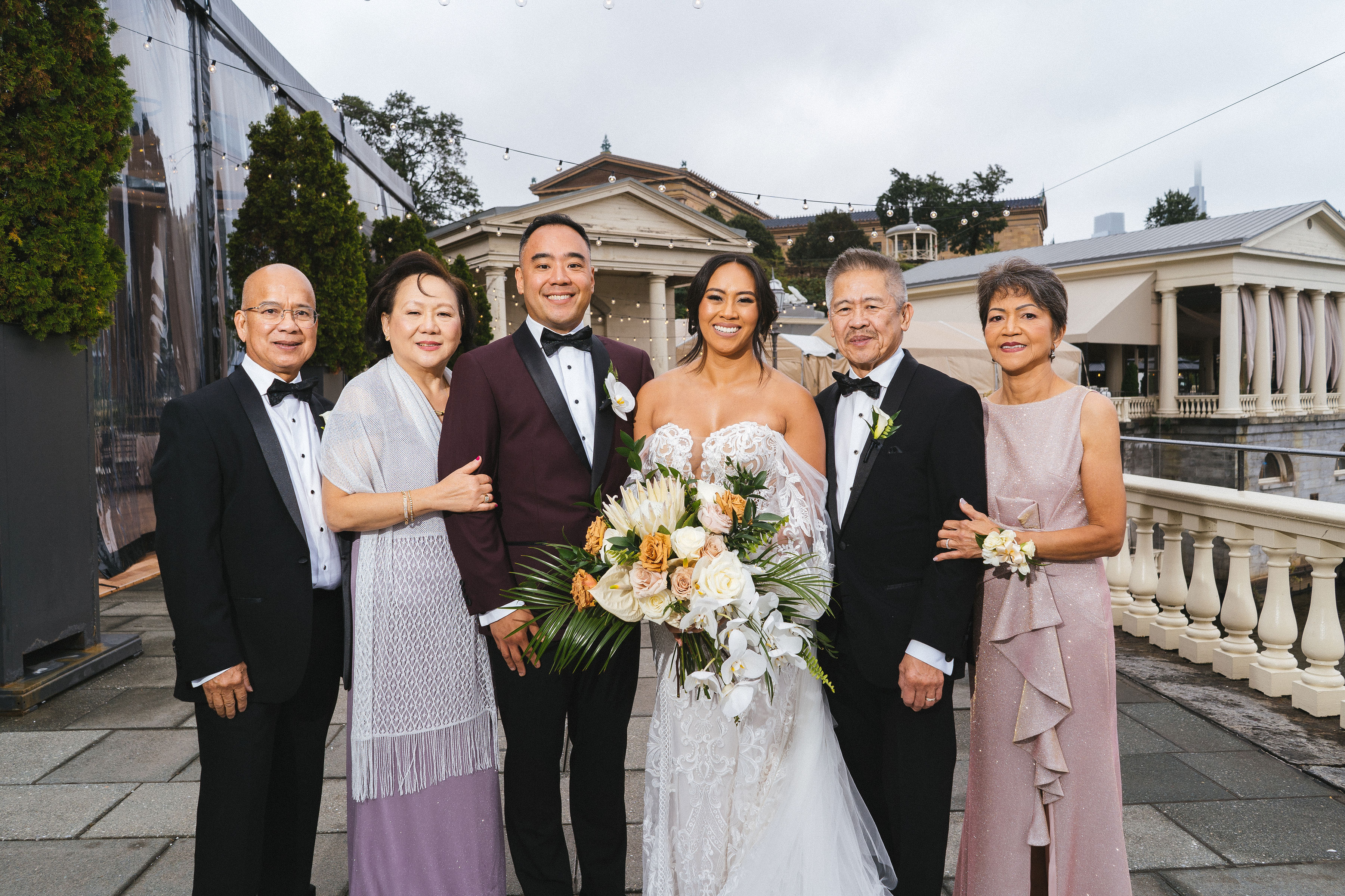 An image of a bride and groom standing with each of their parents.