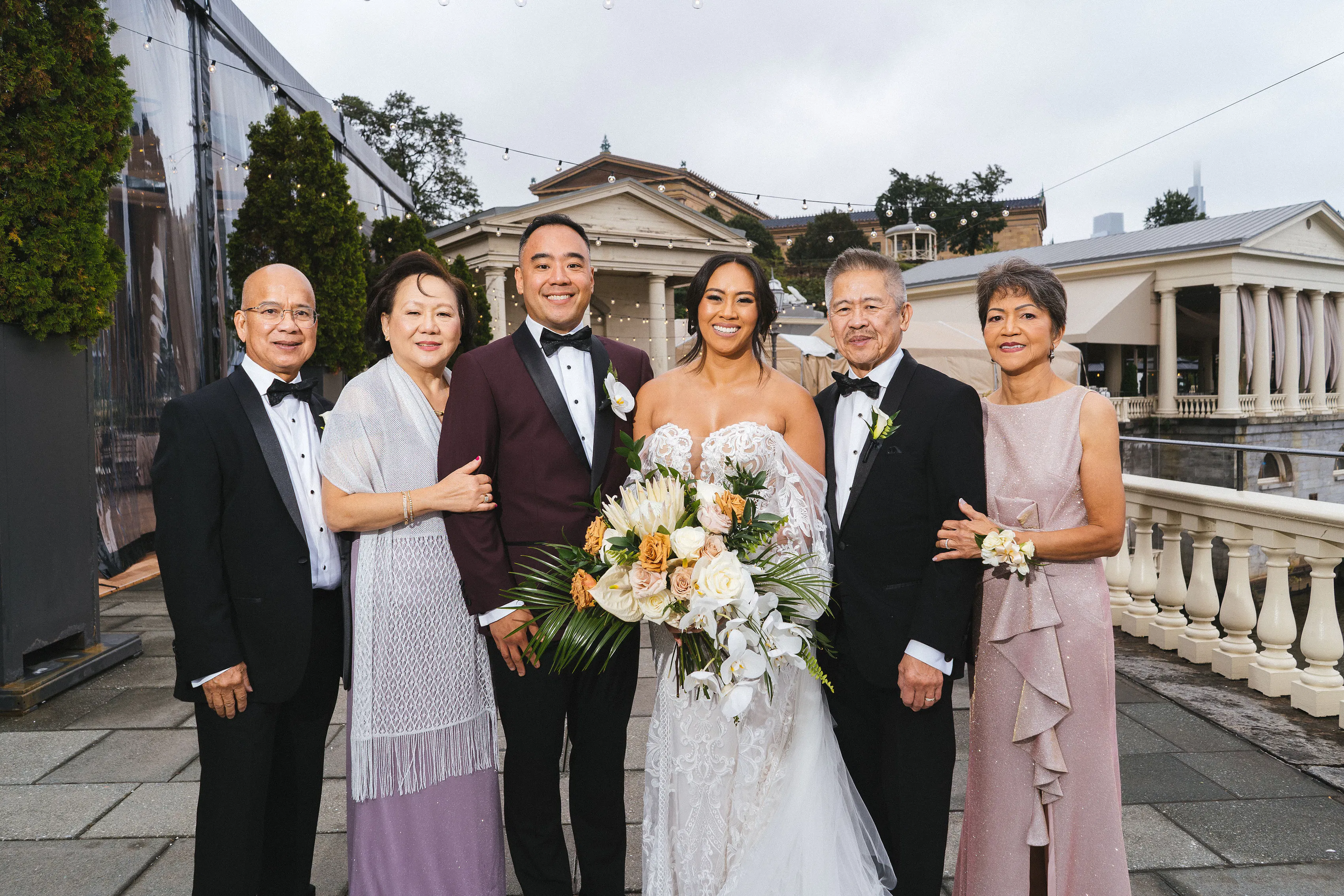 An image of a bride and groom standing with each of their parents.