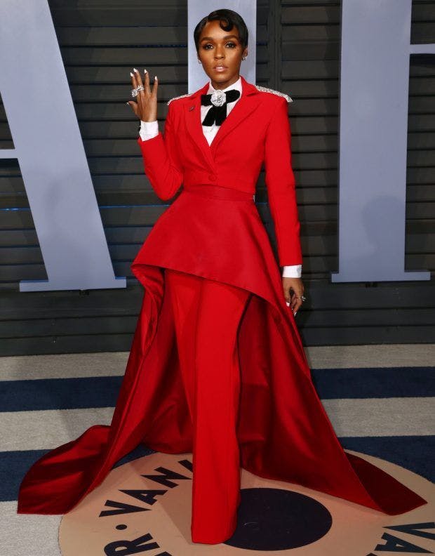 Janelle Monáe at Vanity Fair party in red tuxedo with skirt train.