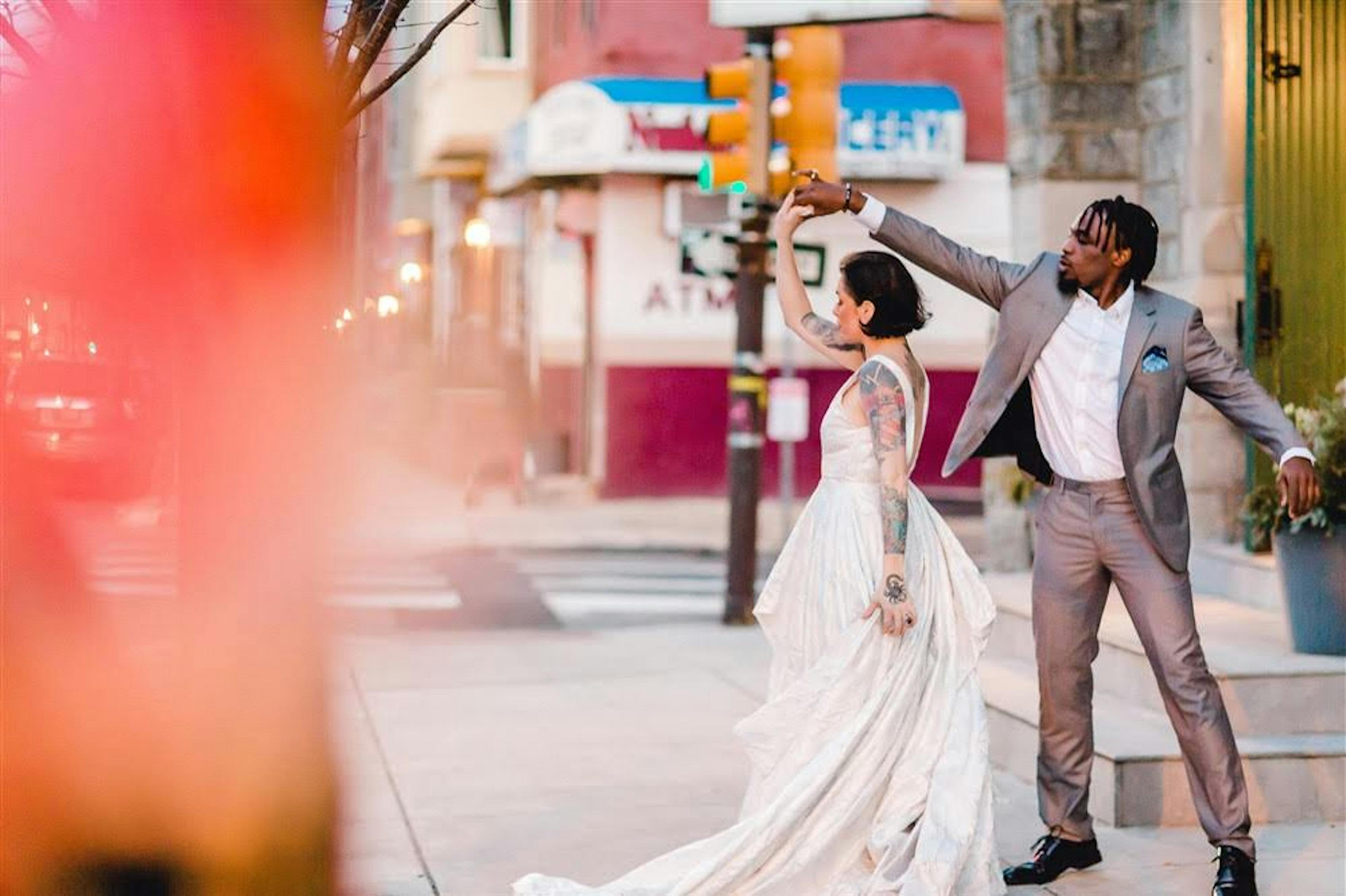 Alternative tattooed couple having a first dance on the city street after chapel wedding ceremony.