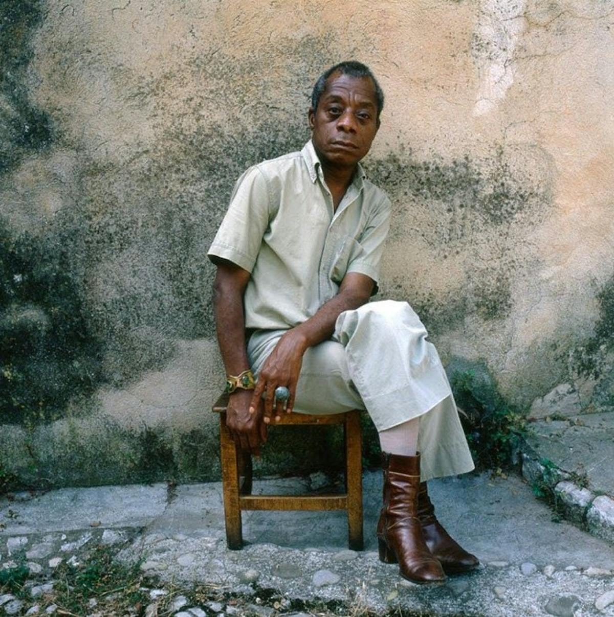 James Baldwin's casual style in airy neutral button down and trousers with brown boots.