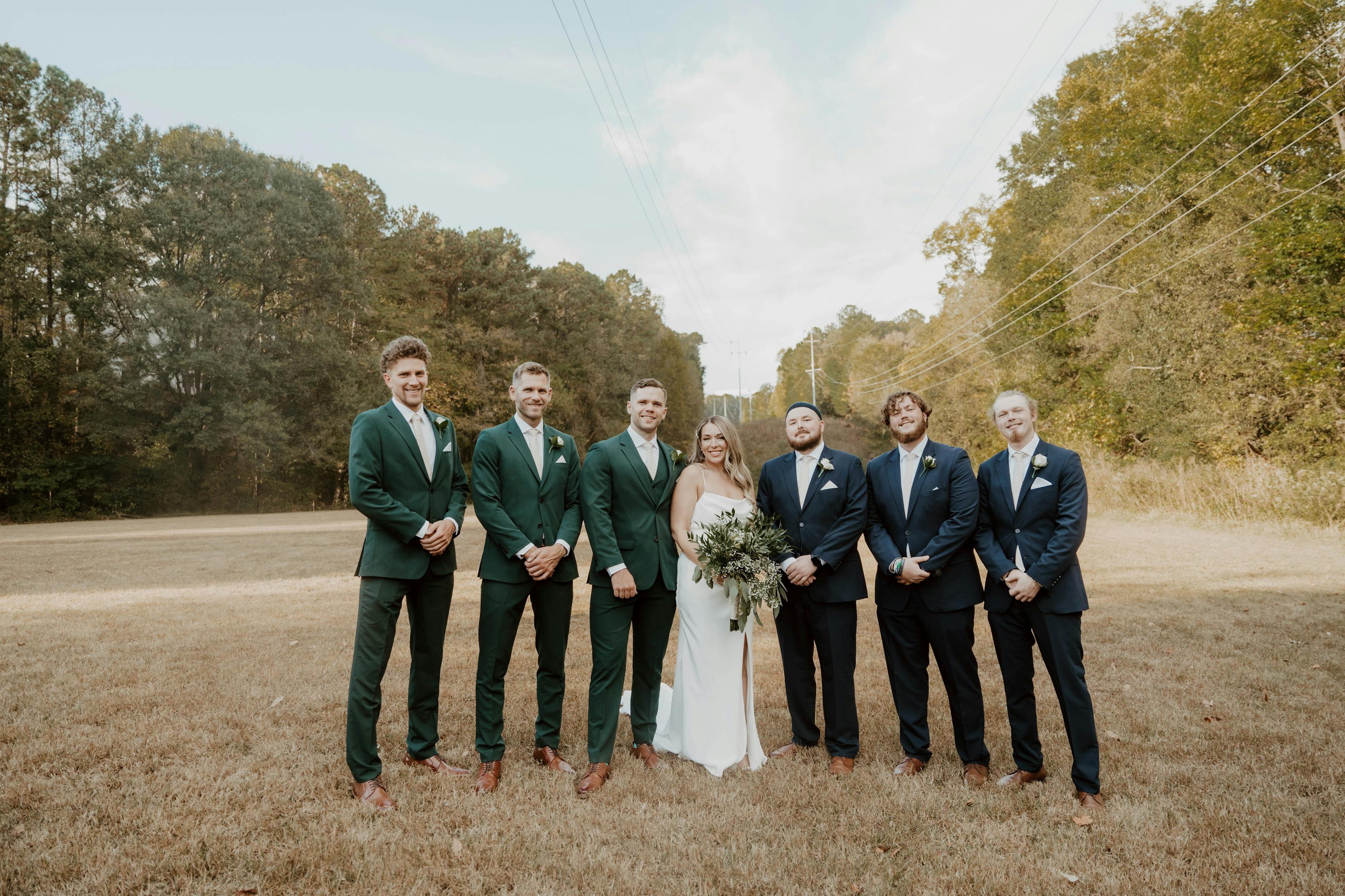 Hunter green and navy blue groomsmen suits.