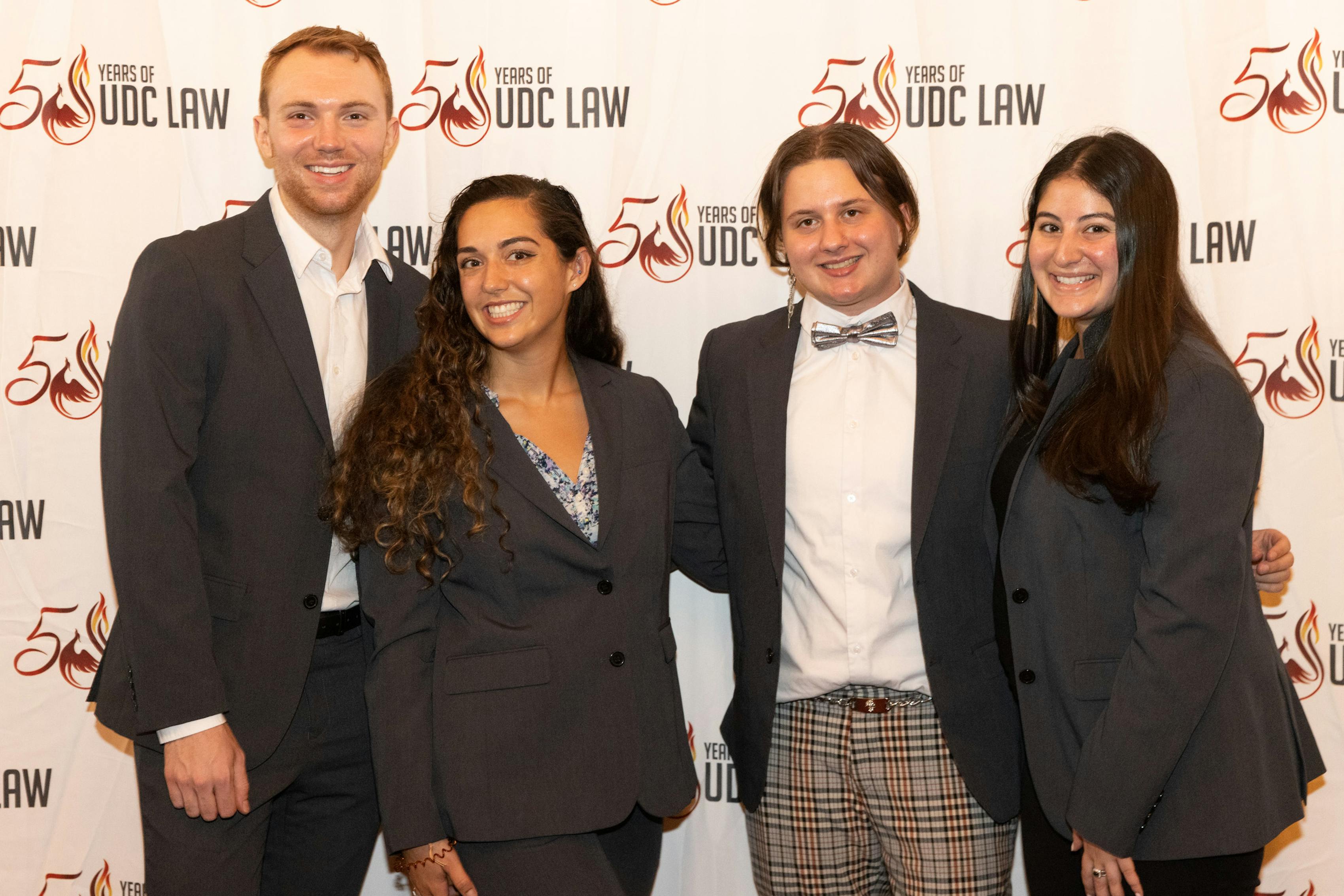 Group of male and female students matching in their charcoal suits for UDC Law School's 50th anniversary.