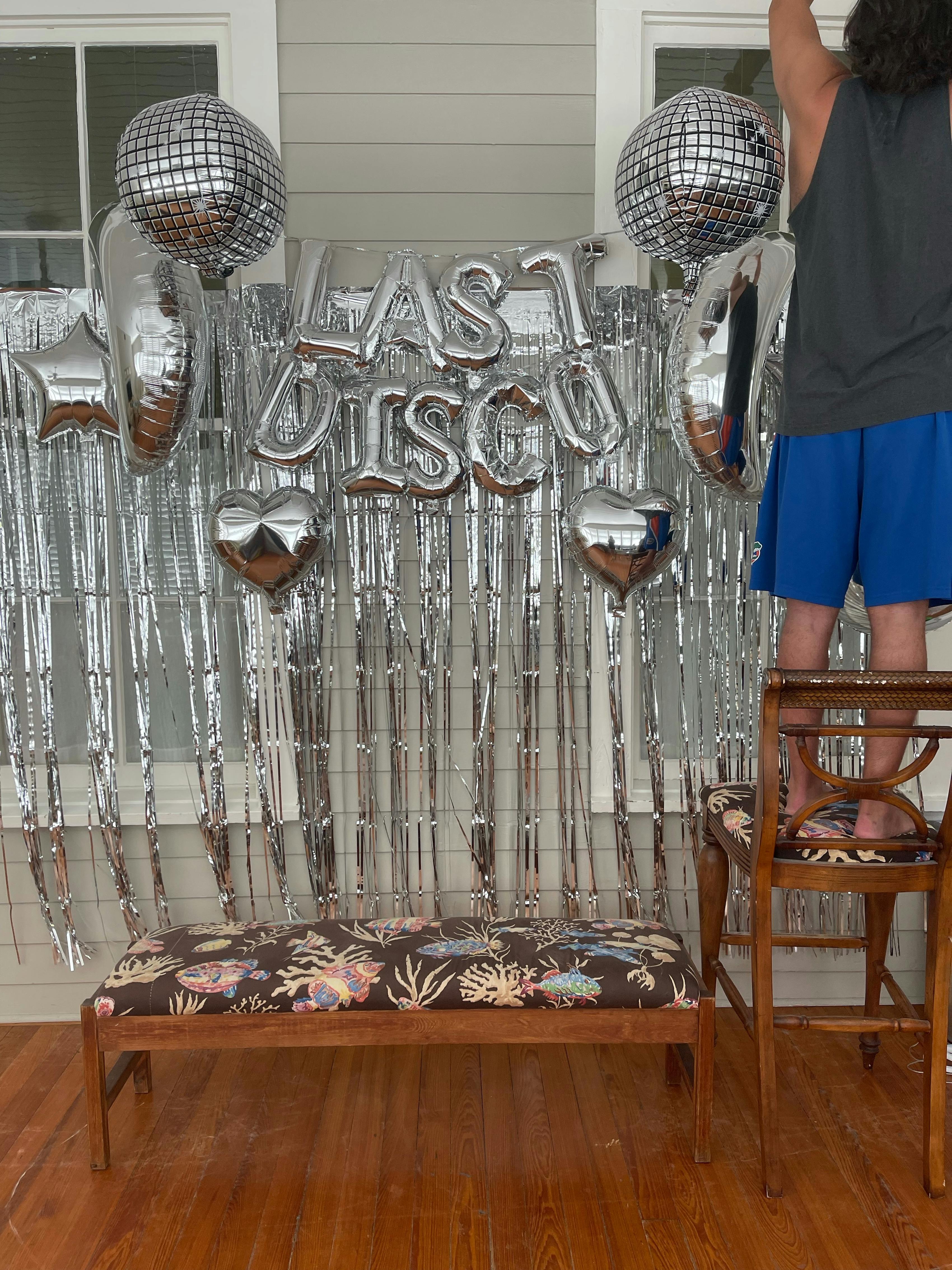 Best man helping to hang bachelor party decor.