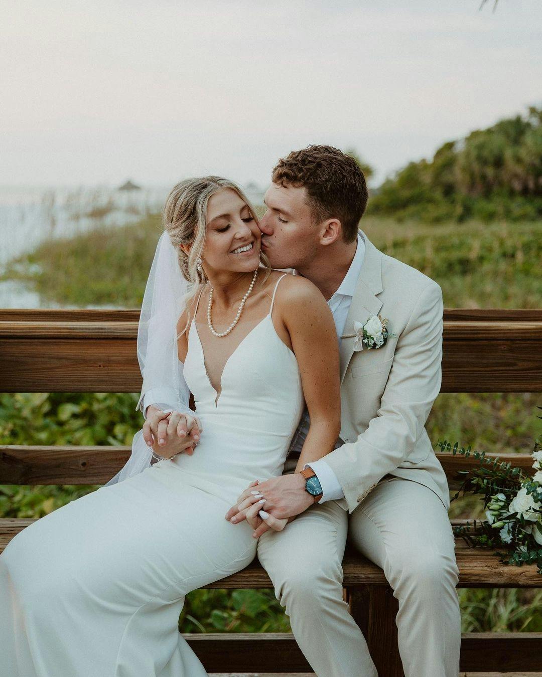 Minimalist bride and groom in simple v neck wedding dress and pearl necklace and modern light tan suit.