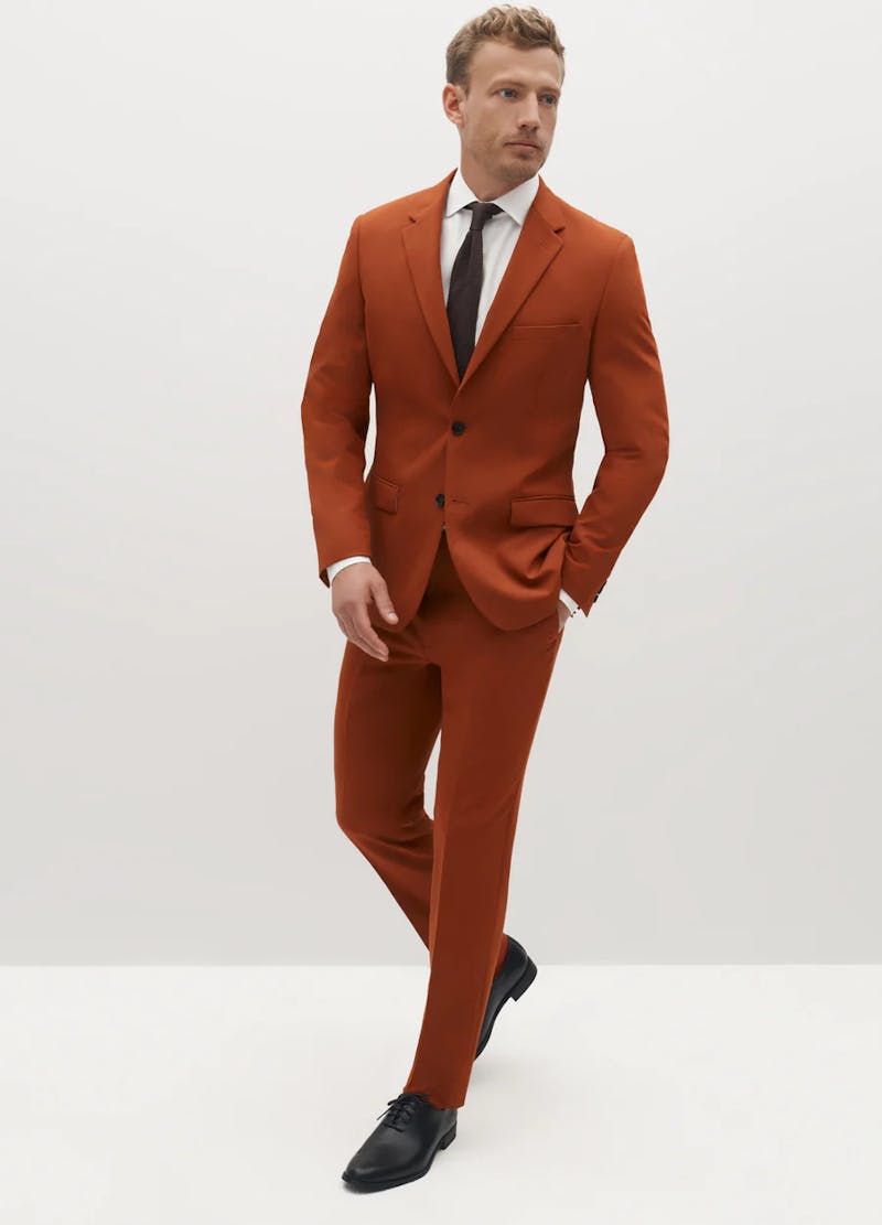 Burnt orange rust suit for men with monochromatic tie for wedding outfit.