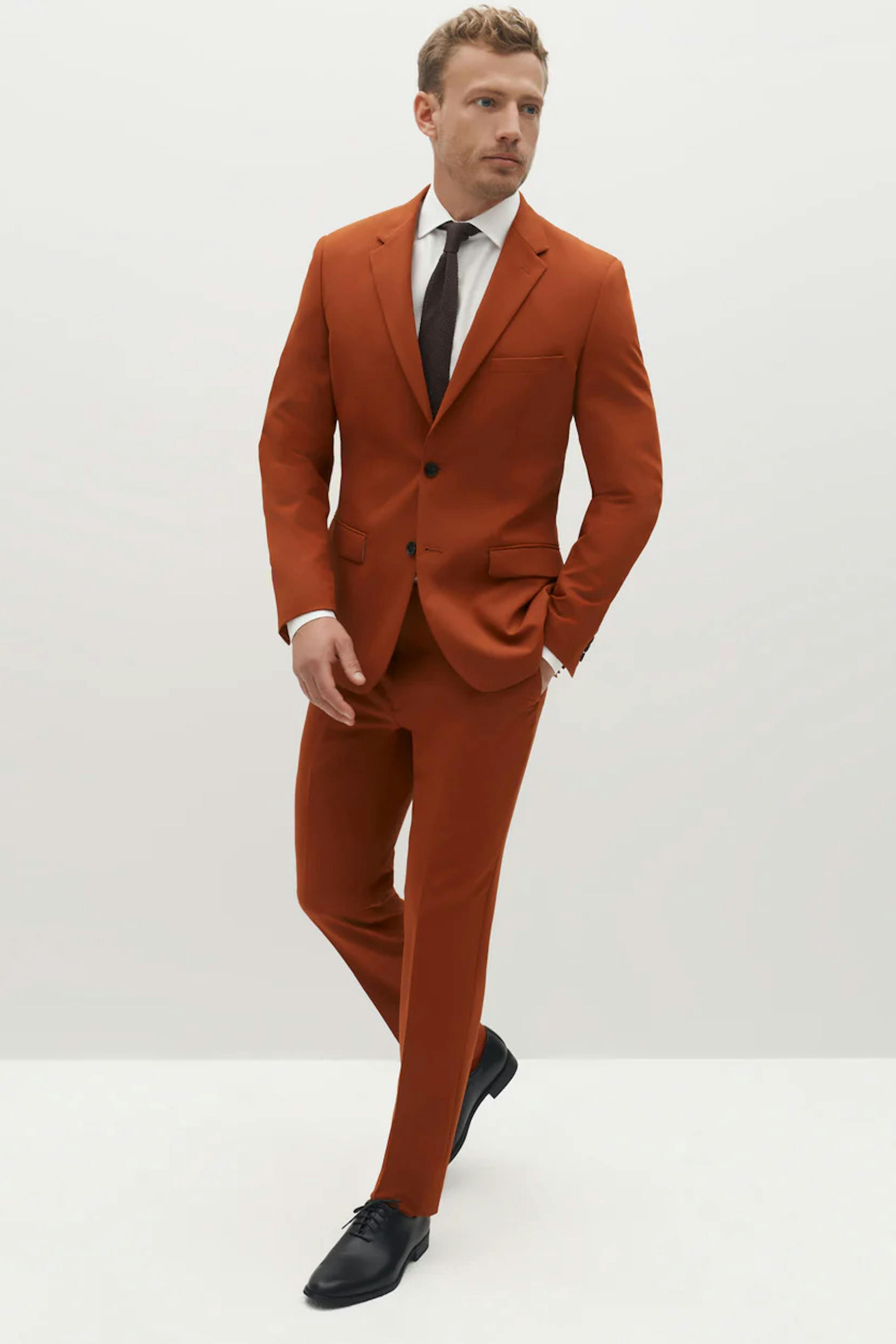 Burnt orange rust suit for men with monochromatic tie for wedding outfit.