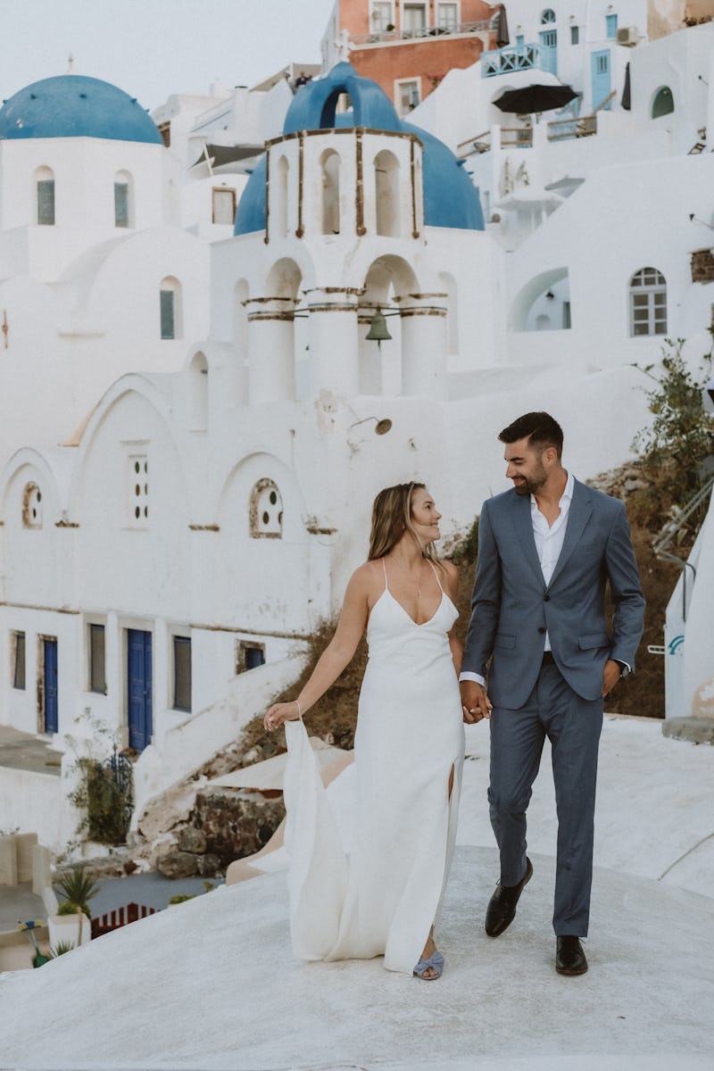 Couple in Santorini at their Destination Elopement wearing light blue suit