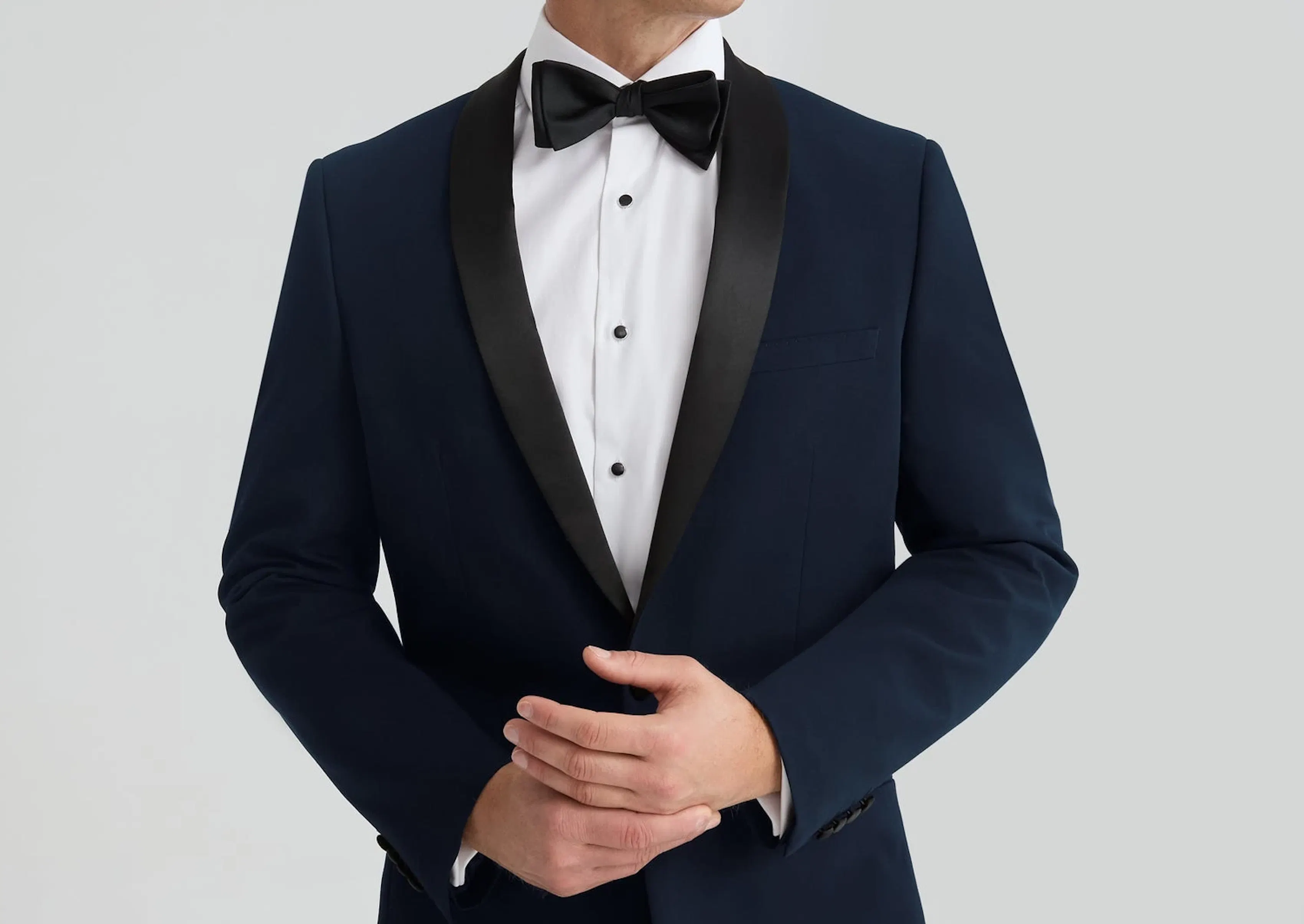 Navy tuxedo with black shawl lapels and black bow tie for a formal wedding or black tie event.