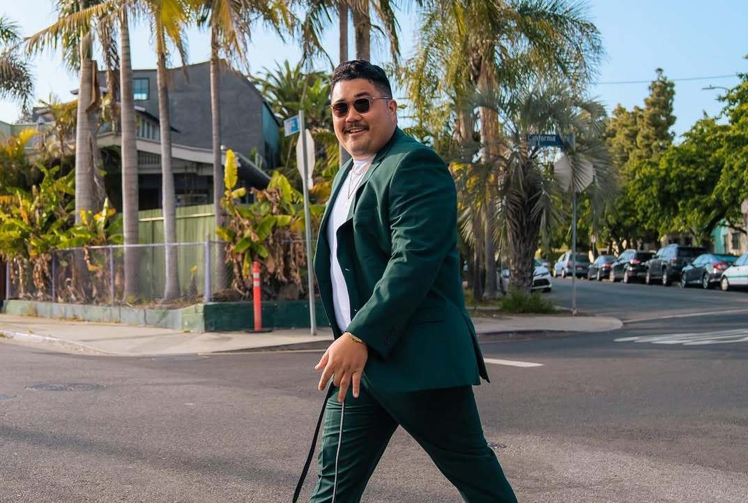 Man wearing a dark green suit jacket and pants for a modern formal look.