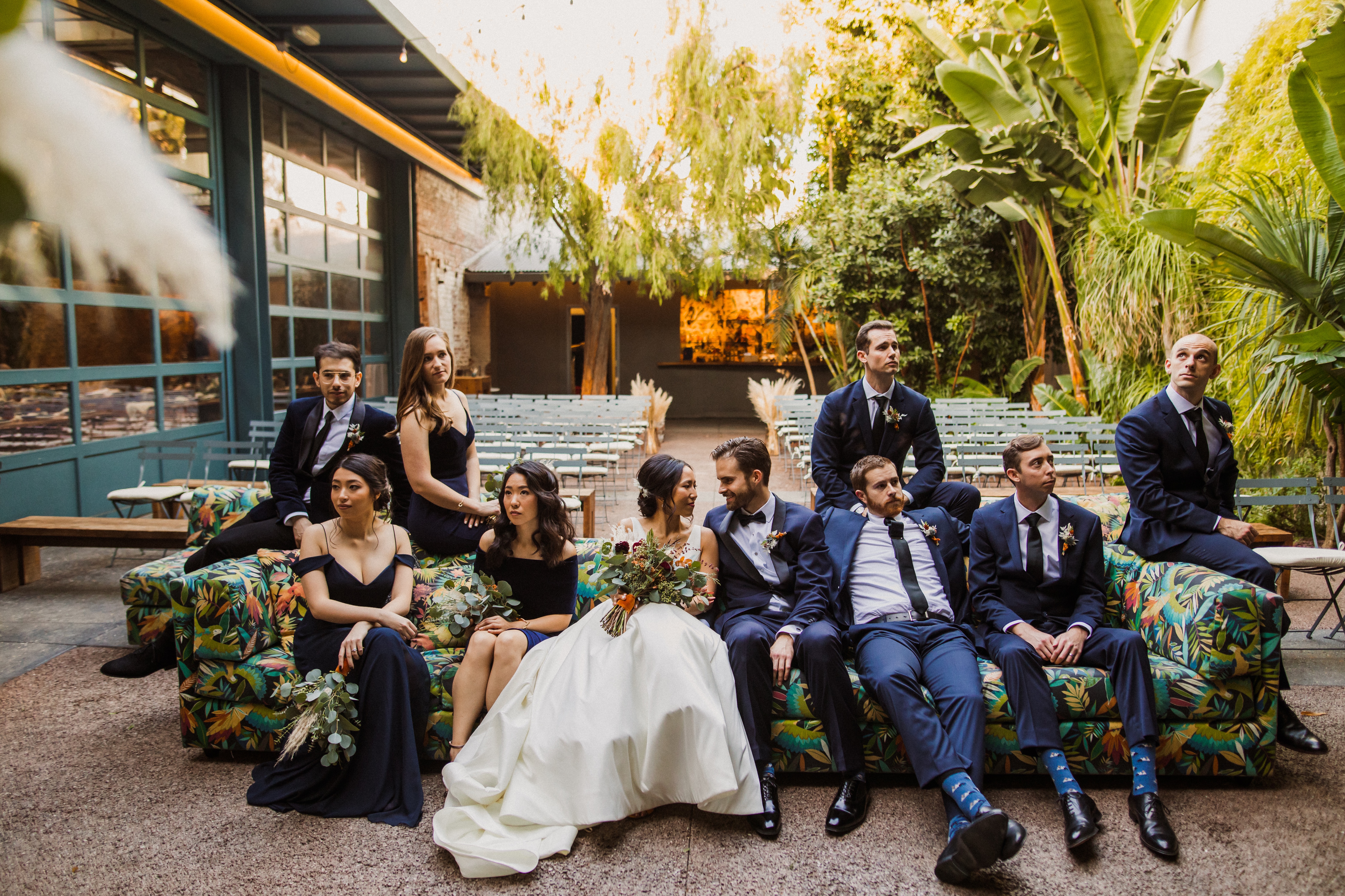 Wedding party wearing navy tuxedos and formal suits for an outdoor wedding celebration.