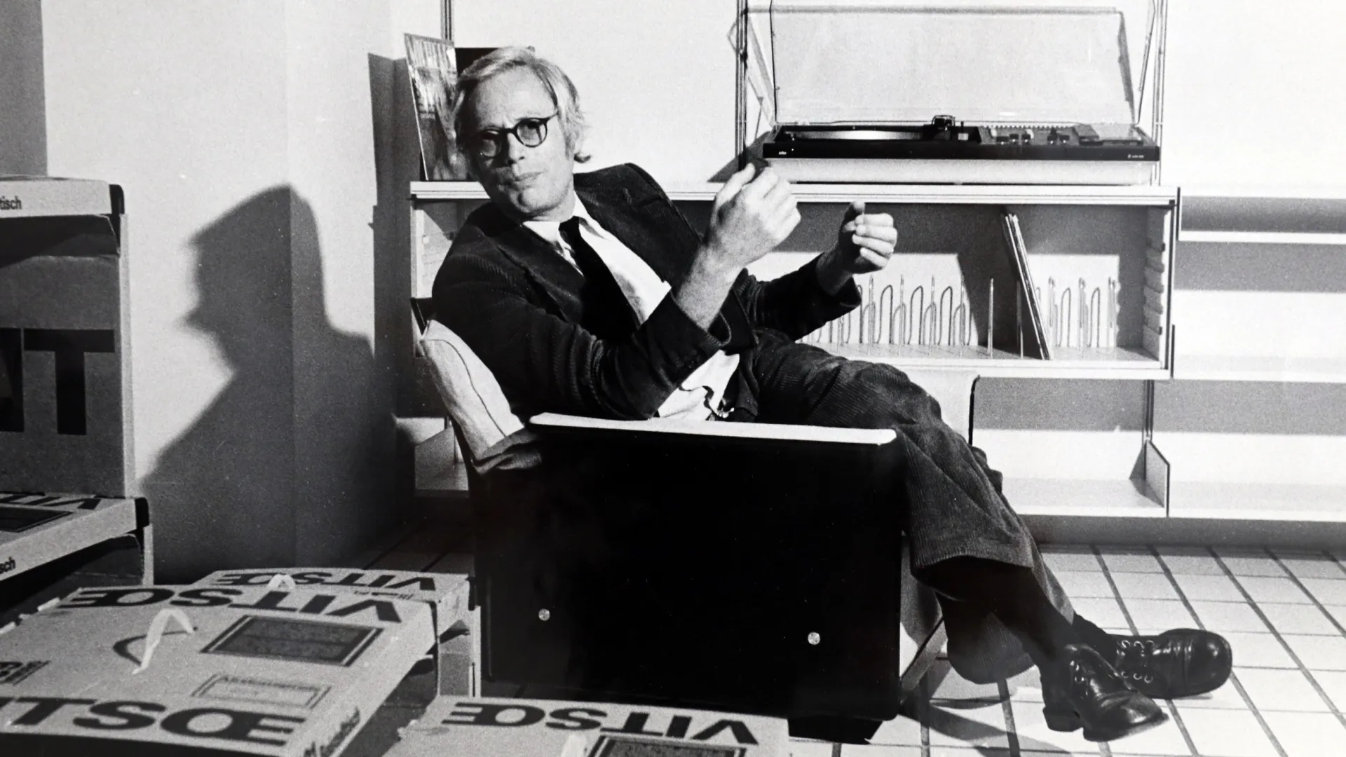 Dieter Rams sits on a Vitsœ 620 armchair in an archival interior photograph.