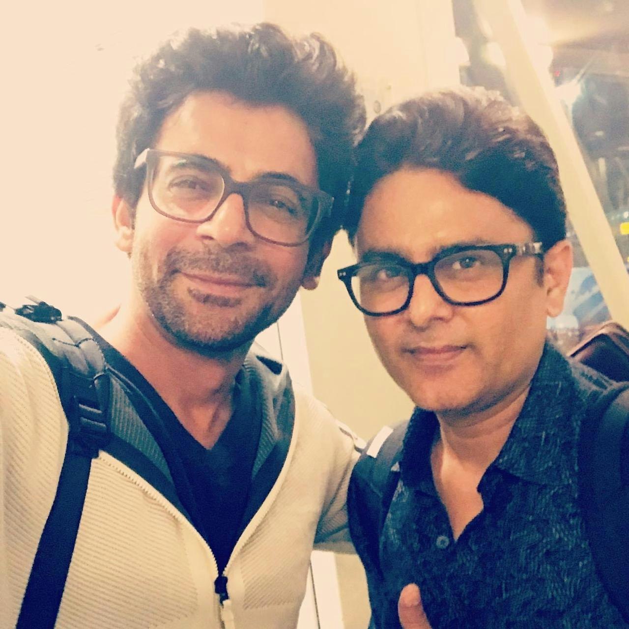 Sunil Grover and celebrity astrologer Sundeep Kochar wearing glasses and smiling for a selfie.
