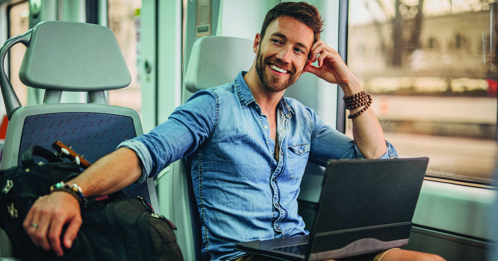 Man travelling on a train with laptop
