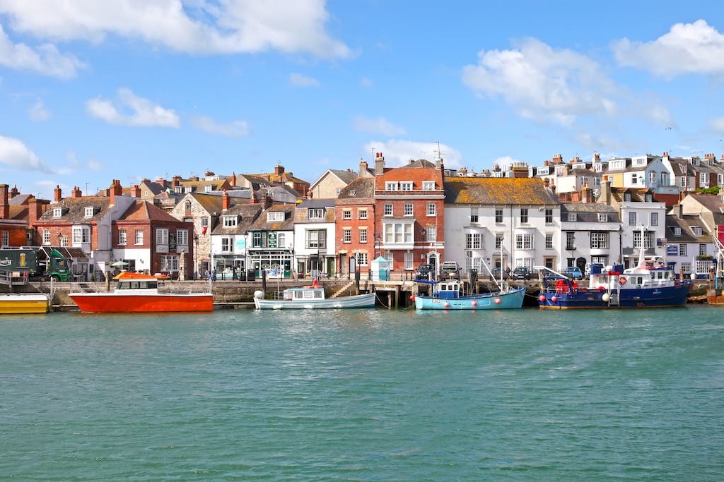Sailing boats off the coast of Weymouth, in Dorset - blue sky in the background