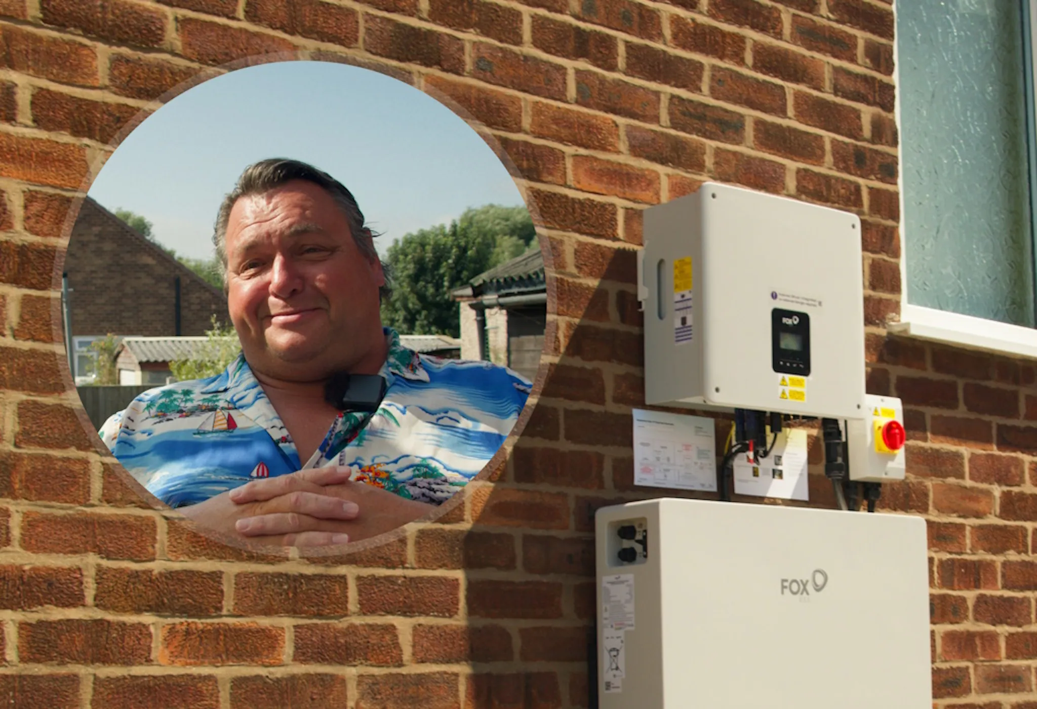 Michael in a circle in front of his battery and inverter on a brick wall