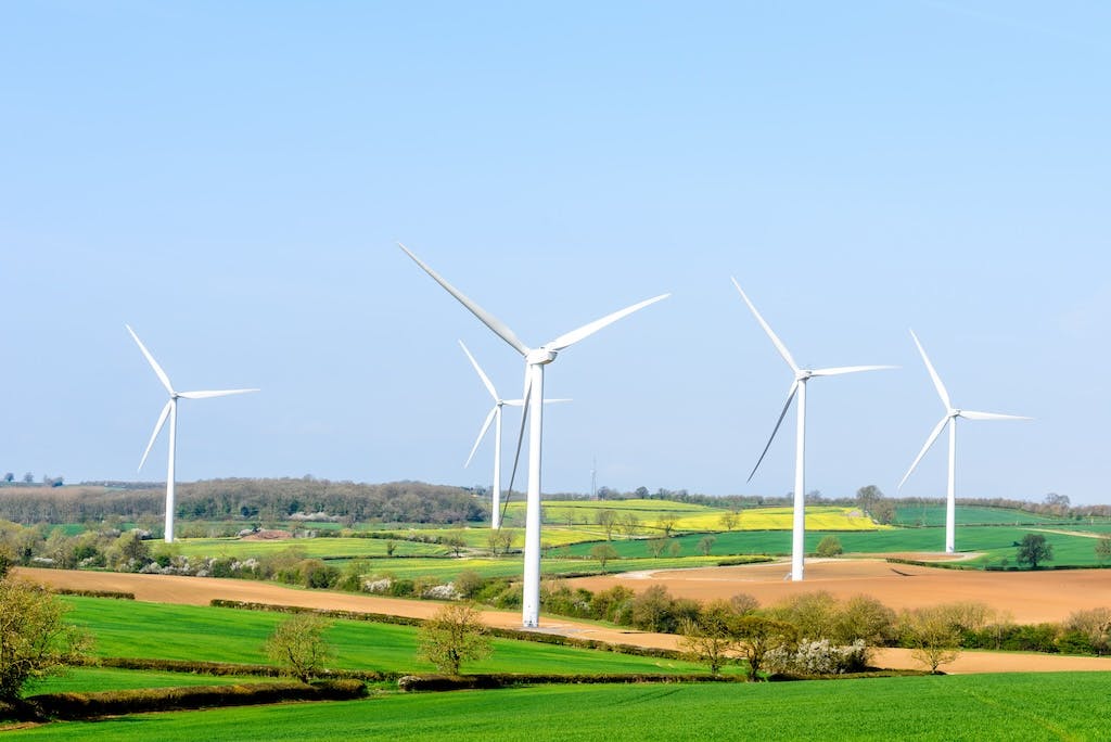 Five wind turbines in the British countryside, blue sky above