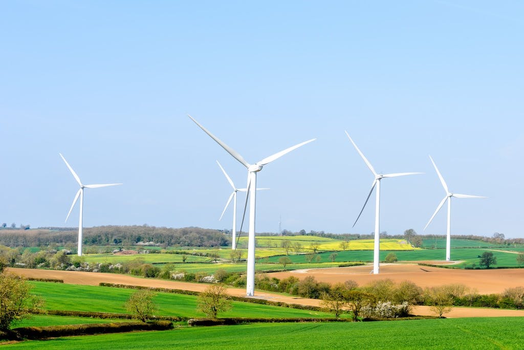Five wind turbines in the British countryside, blue sky above