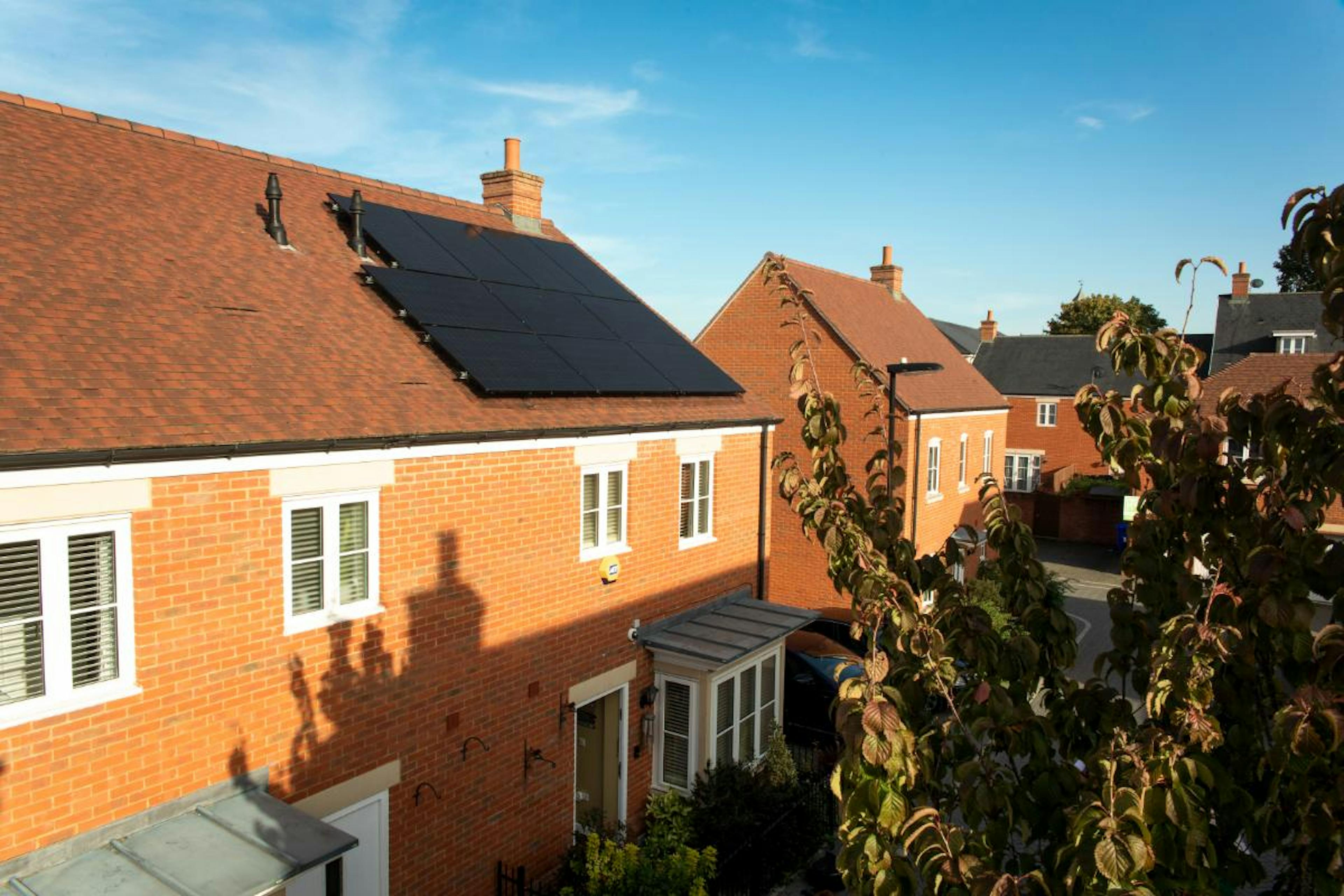 A photo of solar panels on a roof from afar.