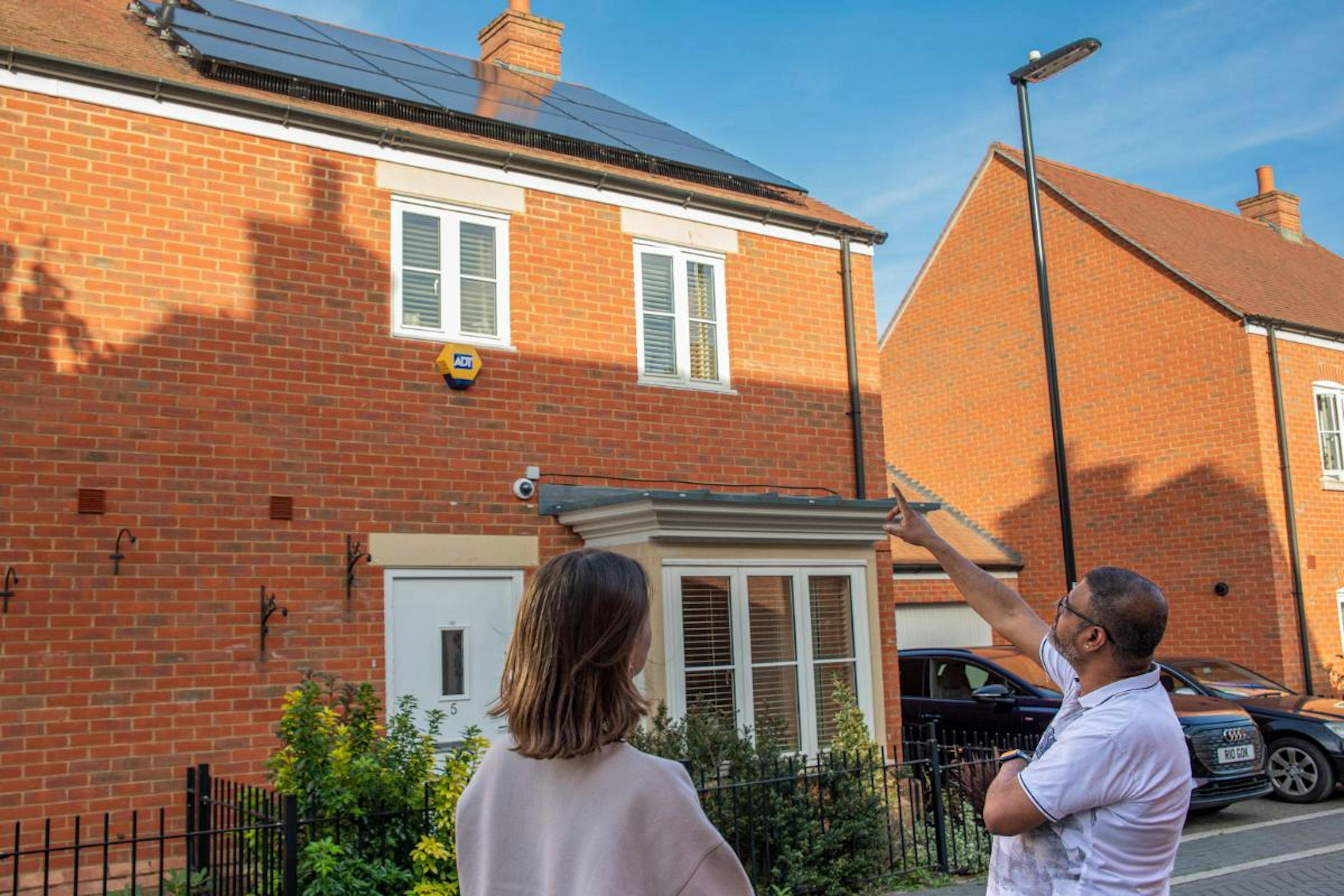 A photo of a customer pointing to his solar panels