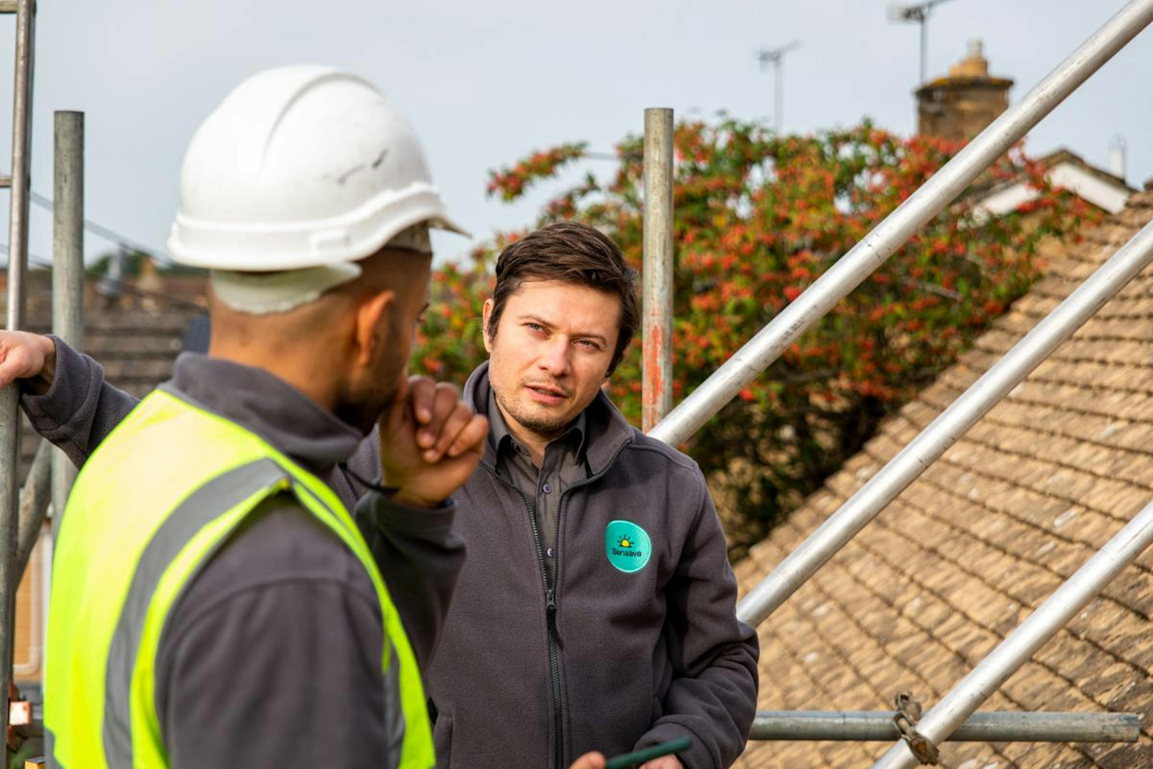 A photo of two people talking on scaffolding