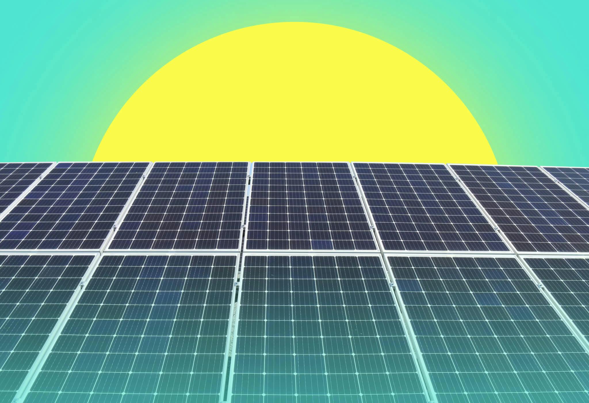 The sun rising behind an array of polycrystalline solar panels