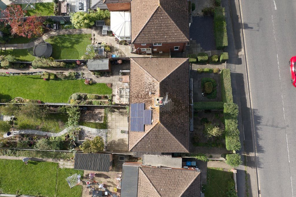 A bird's eye view of a black solar panel array on a semi-detached property in England