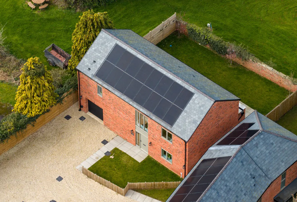 black solar panels on a grey roof, on a brick building